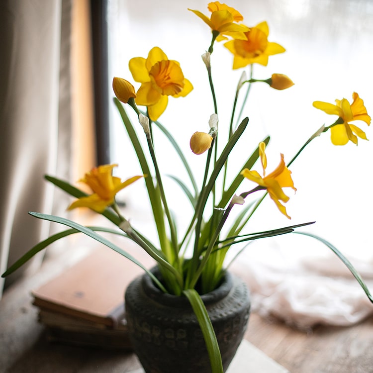A vibrant 19-inch tall artificial silk yellow daffodil flower stem with two blooms and one bud, featuring realistic green leaves.