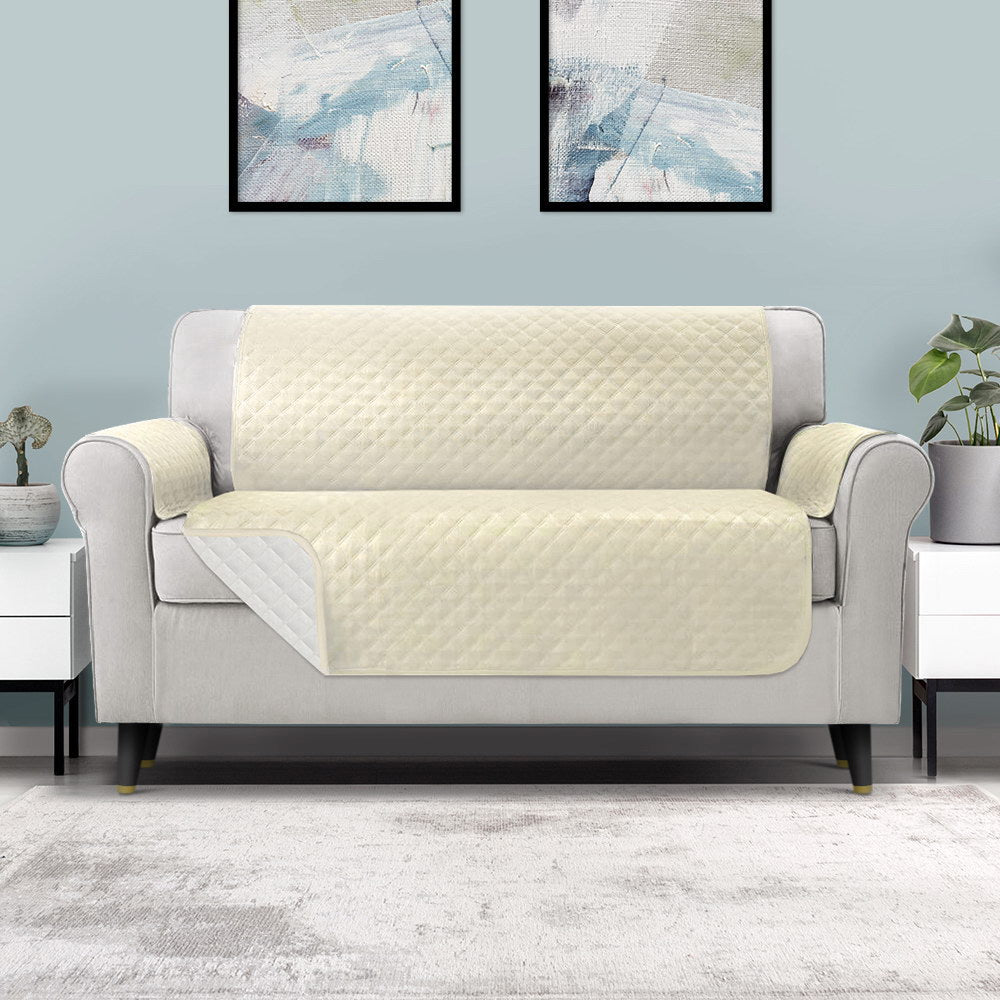 Artiss 3 Seater Sofa Cover in beige, featuring a diamond-quilted design and water-resistant fabric, draped over a stylish couch.