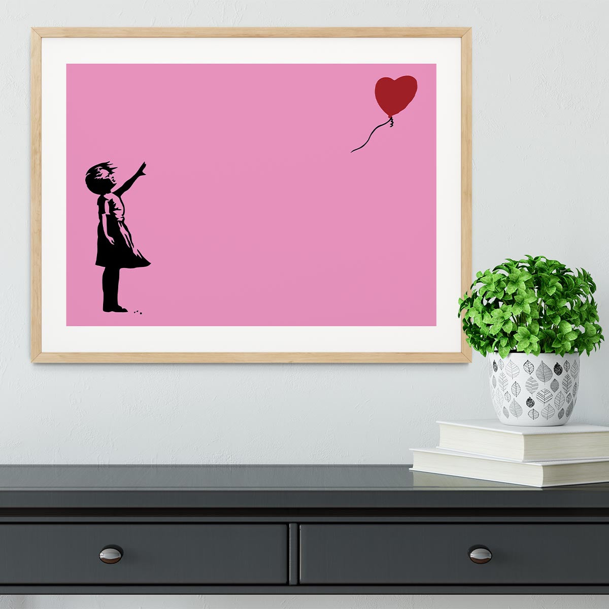Banksy Balloon Heart Girl Pink Framed Print showcasing a girl reaching for a heart-shaped balloon, framed in a stylish handmade frame.