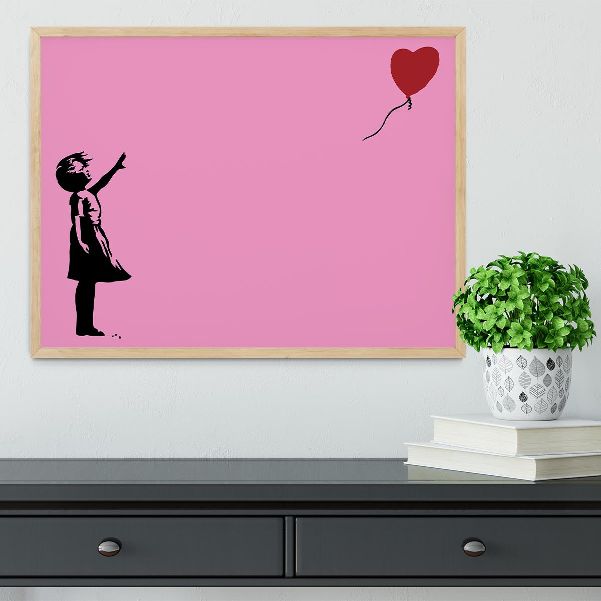 Banksy Balloon Heart Girl Pink Framed Print showcasing a girl reaching for a heart-shaped balloon, framed in a stylish handmade frame.