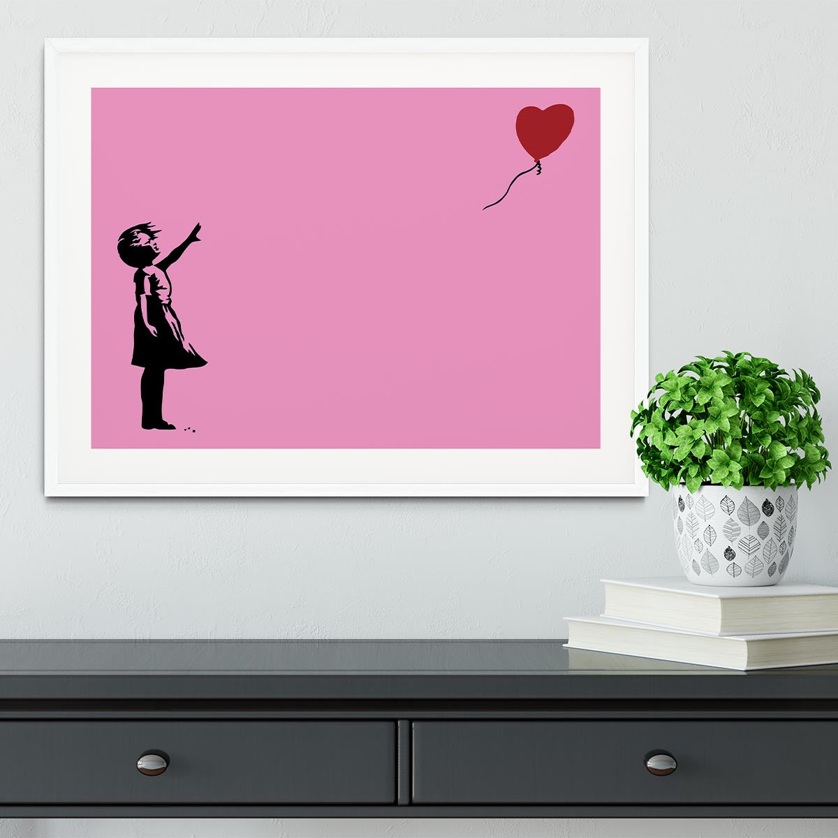 Banksy Balloon Heart Girl Pink Framed Print showcasing a girl reaching for a heart-shaped balloon, framed in a stylish handmade frame.