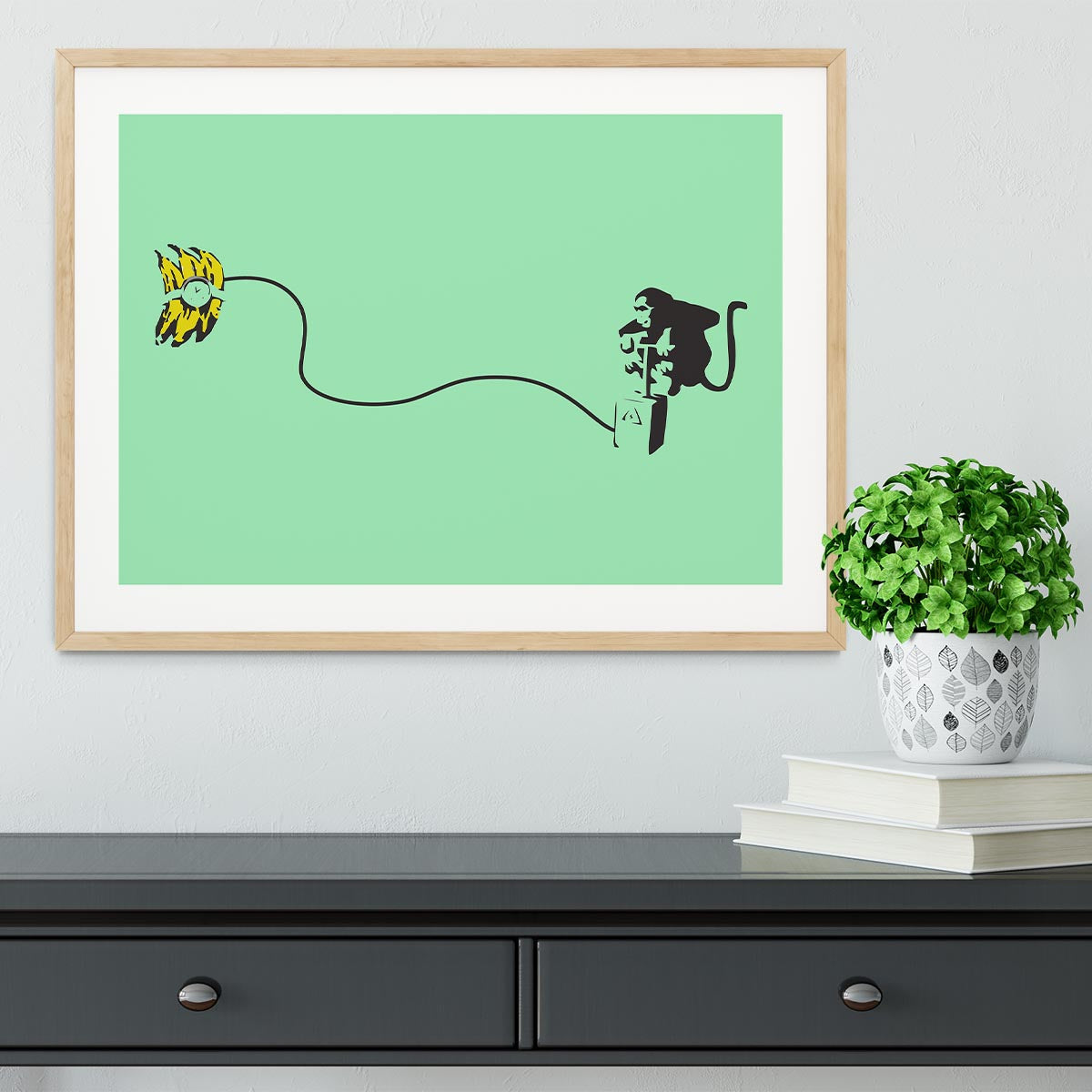 Banksy Monkey Banana Bomb Green Framed Print featuring a playful monkey holding a banana bomb in vibrant colors.