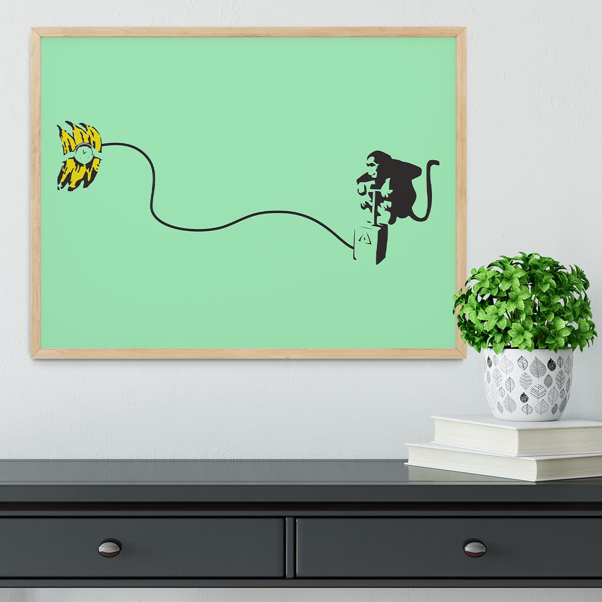 Banksy Monkey Banana Bomb Green Framed Print featuring a playful monkey holding a banana bomb in vibrant colors.