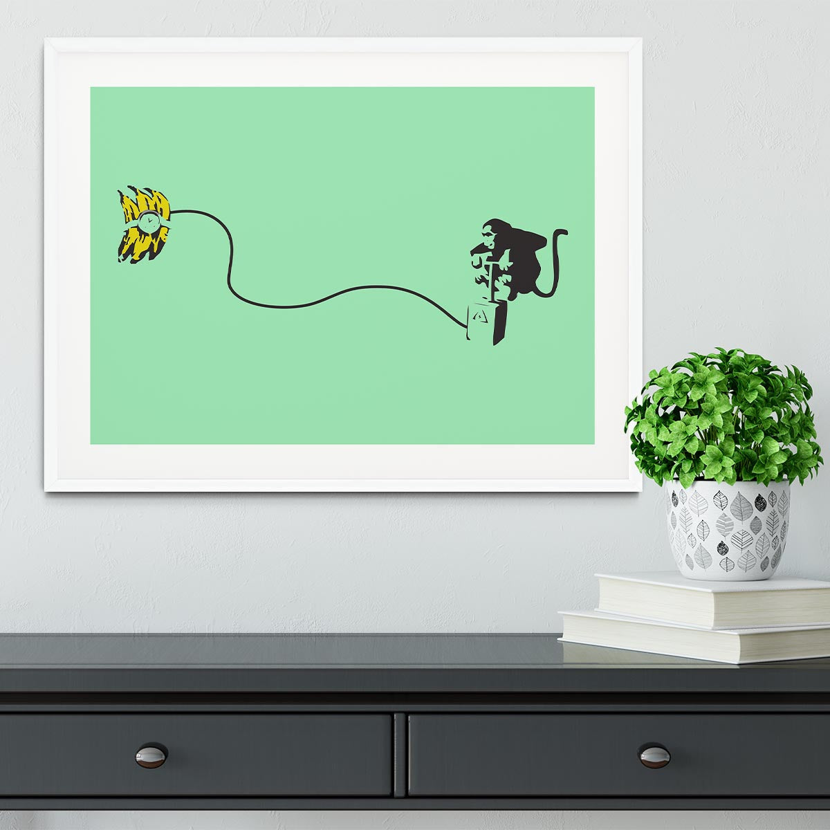 Banksy Monkey Banana Bomb Green Framed Print featuring a playful monkey holding a banana bomb in vibrant colors.