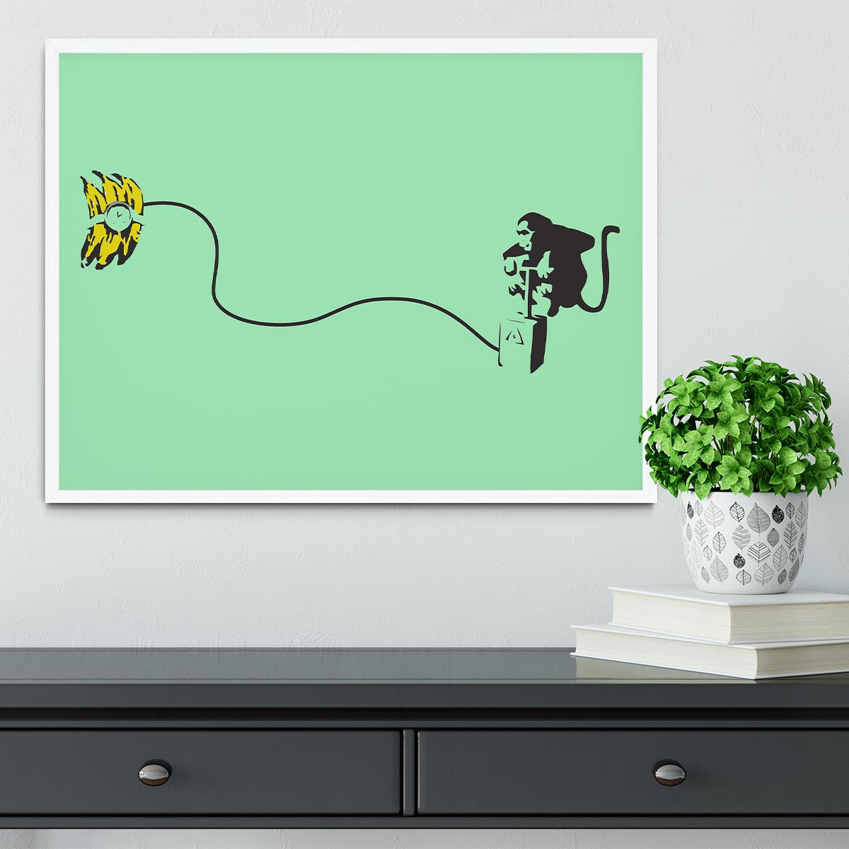 Banksy Monkey Banana Bomb Green Framed Print featuring a playful monkey holding a banana bomb in vibrant colors.