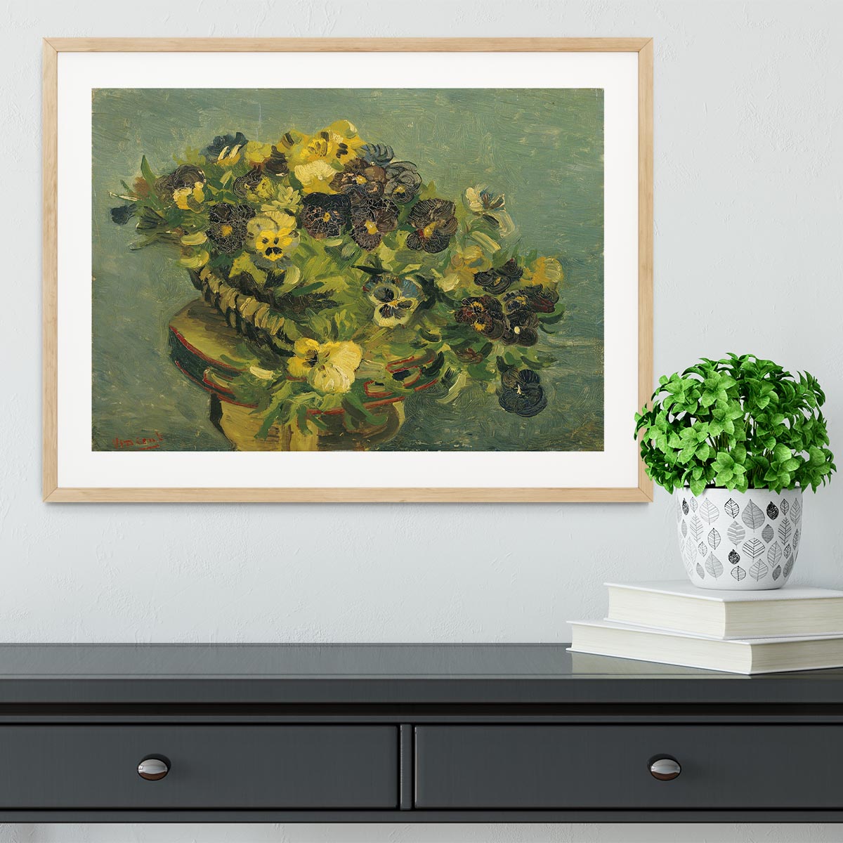Framed print of Van Gogh's Basket of Pansies on a small table, showcasing vibrant colors and intricate details.