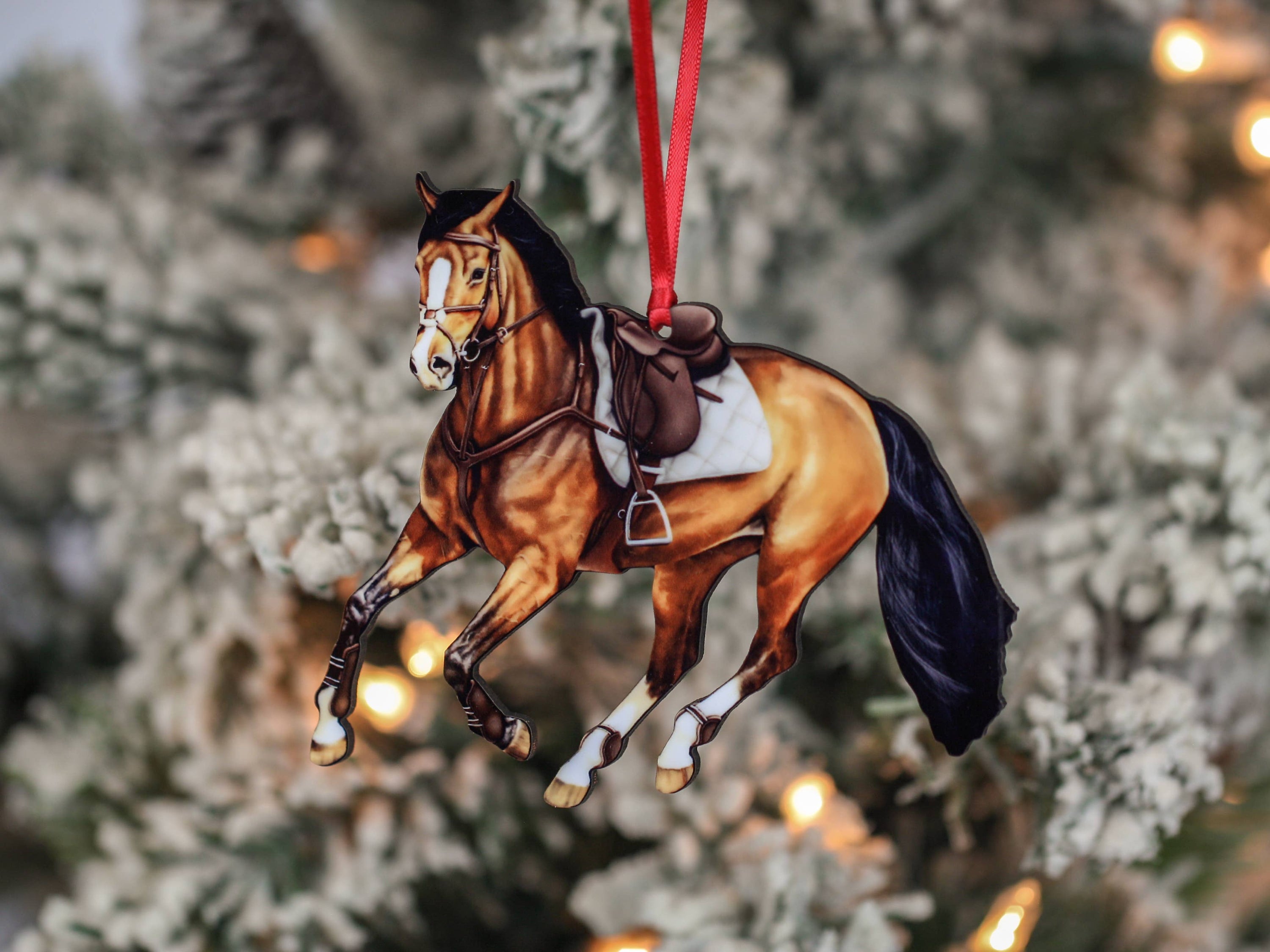 A beautifully crafted bay galloping jumper horse ornament made of composite wood, featuring red and black ribbons, perfect for Christmas and year-round display.
