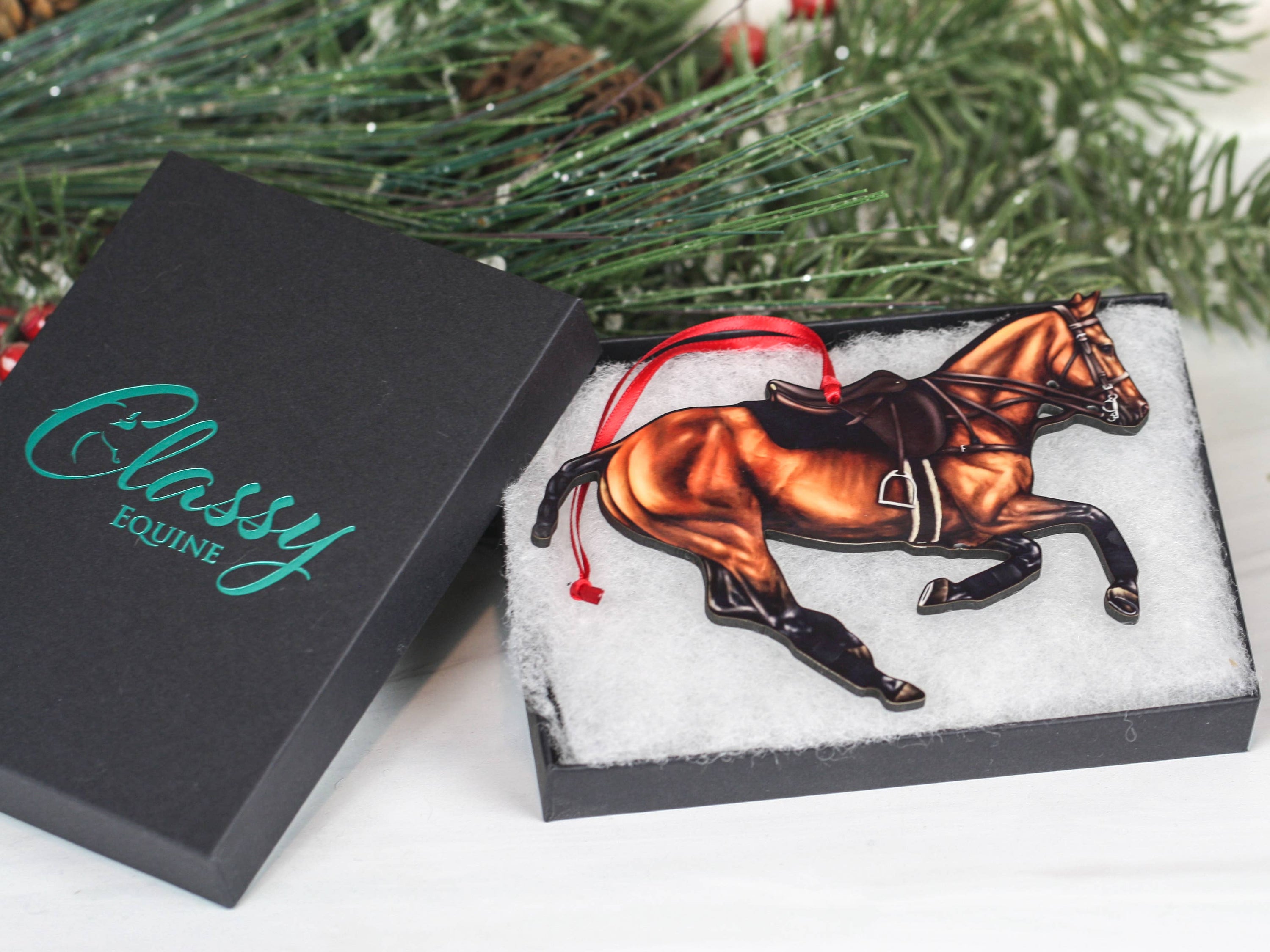 Handcrafted Bay Polo Pony Christmas Ornament with red and black ribbons, showcasing a galloping horse design, perfect for equestrian decor.