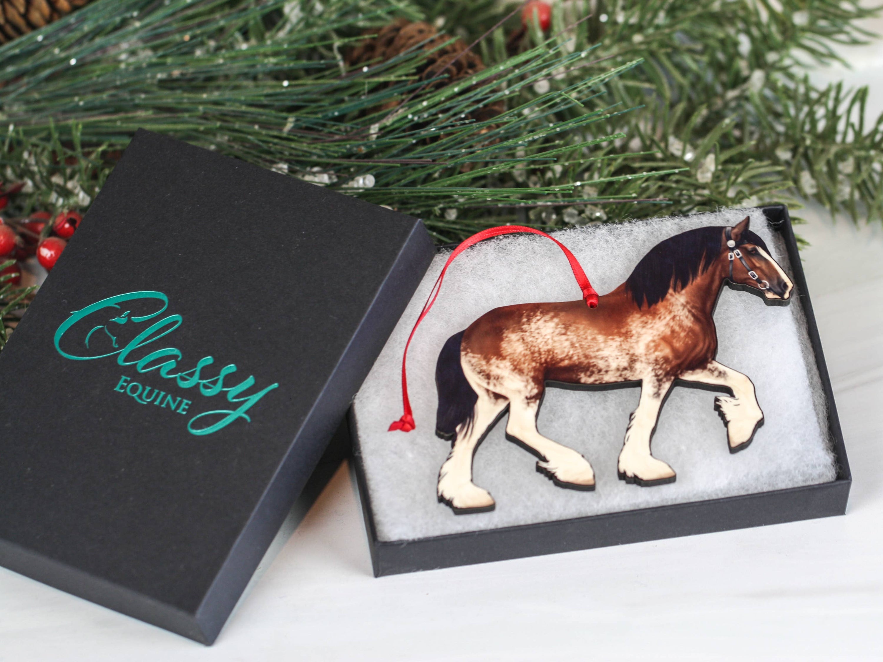 Bay Sabino Shire Draft Horse Christmas Ornament with red and black ribbons, showcasing intricate laser-cut details.