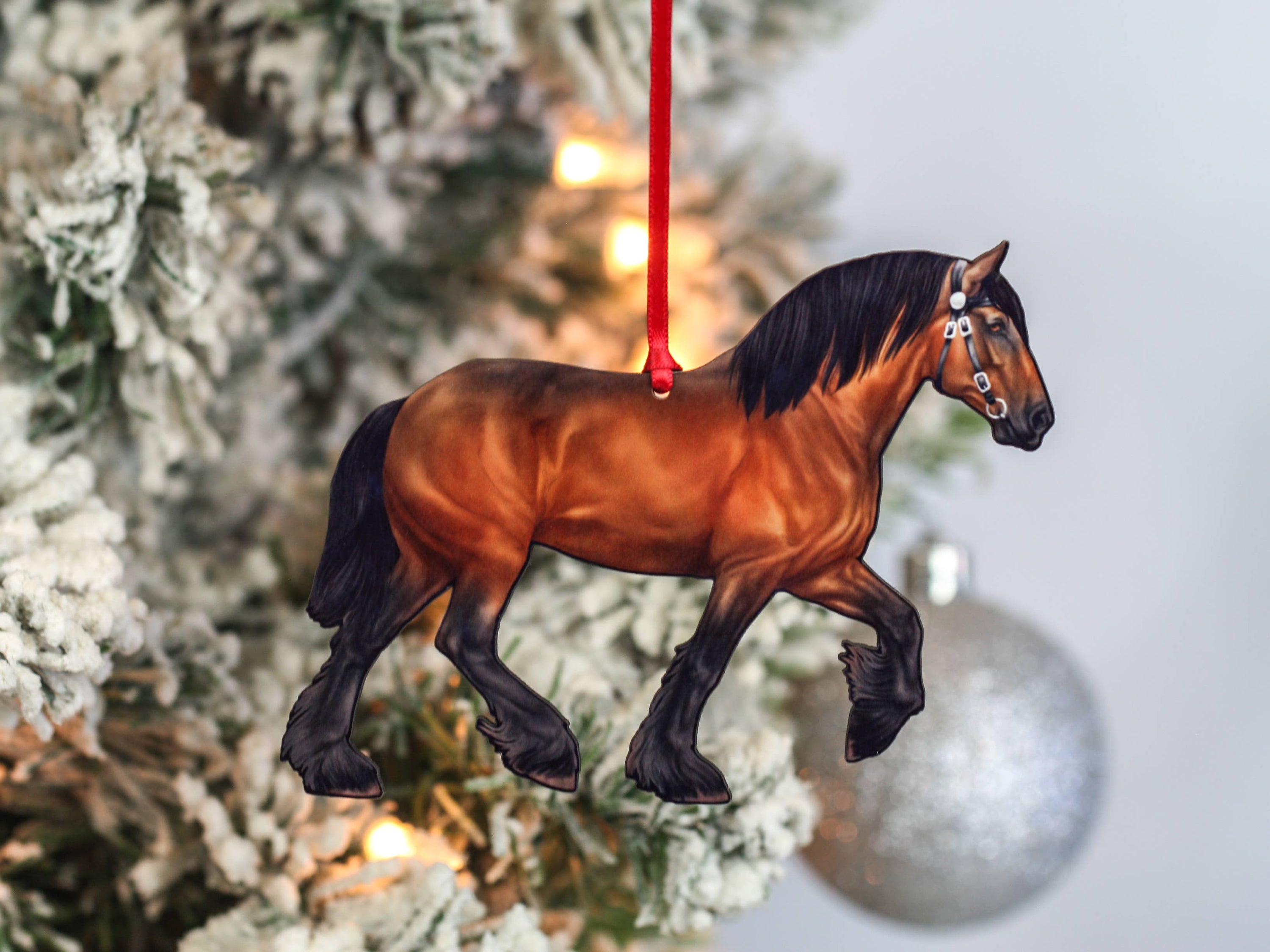 A beautifully crafted Bay Shire Draft Horse Ornament made from composite wood, featuring a glossy front and dark brown back, adorned with red and black ribbons.