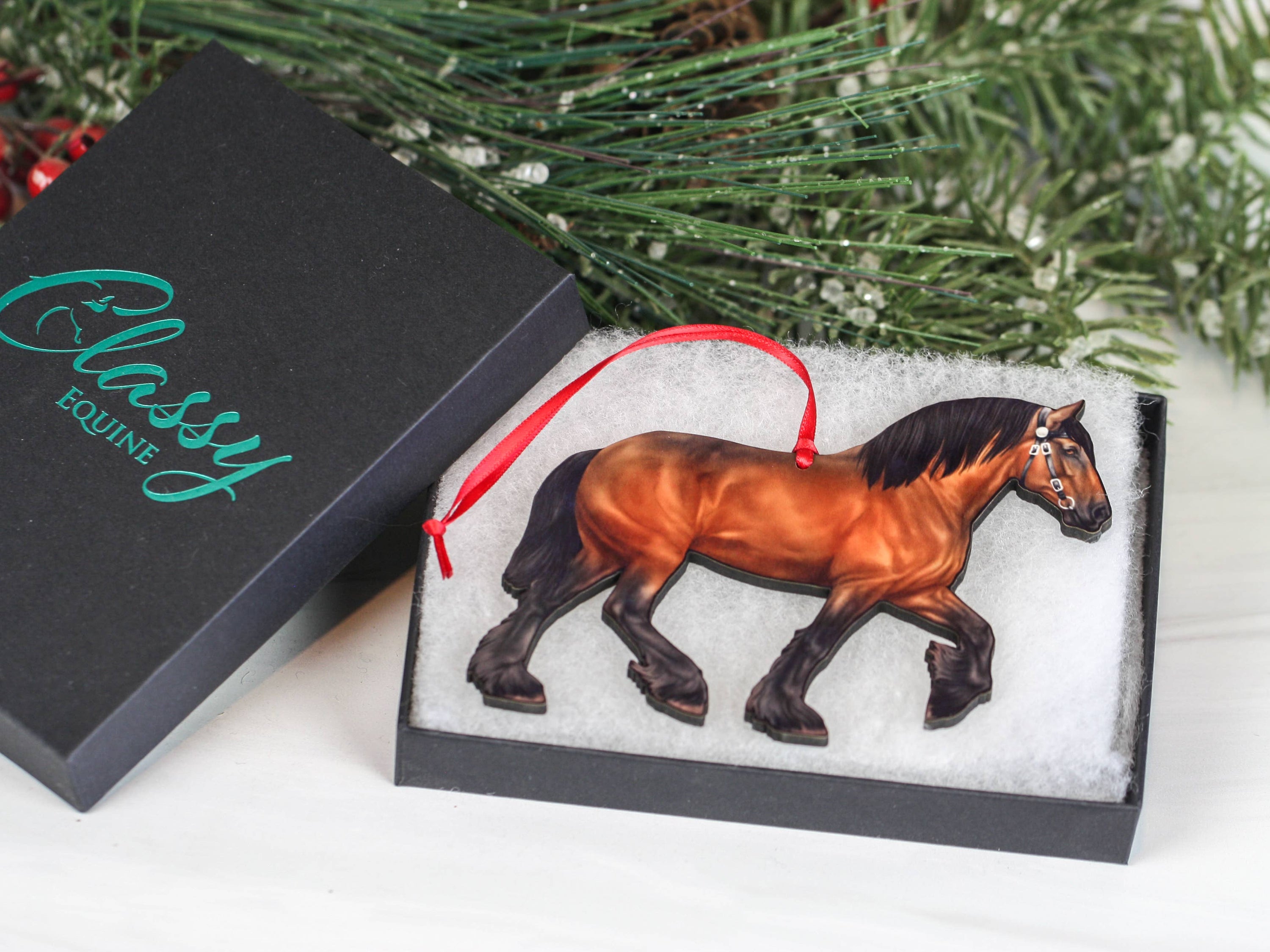 A beautifully crafted Bay Shire Draft Horse Ornament made from composite wood, featuring a glossy front and dark brown back, adorned with red and black ribbons.