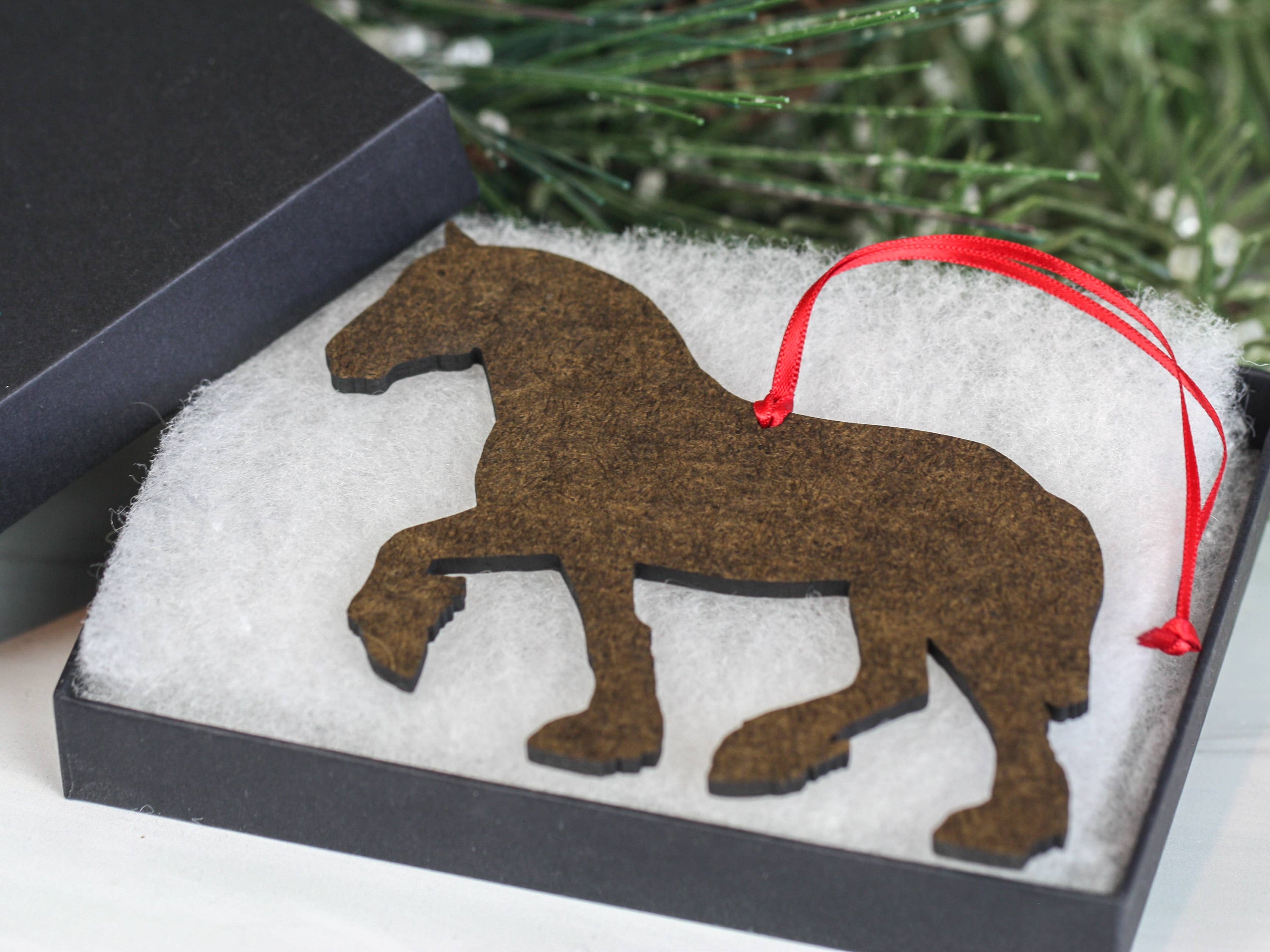A beautifully crafted Bay Shire Draft Horse Ornament made from composite wood, featuring a glossy front and dark brown back, adorned with red and black ribbons.