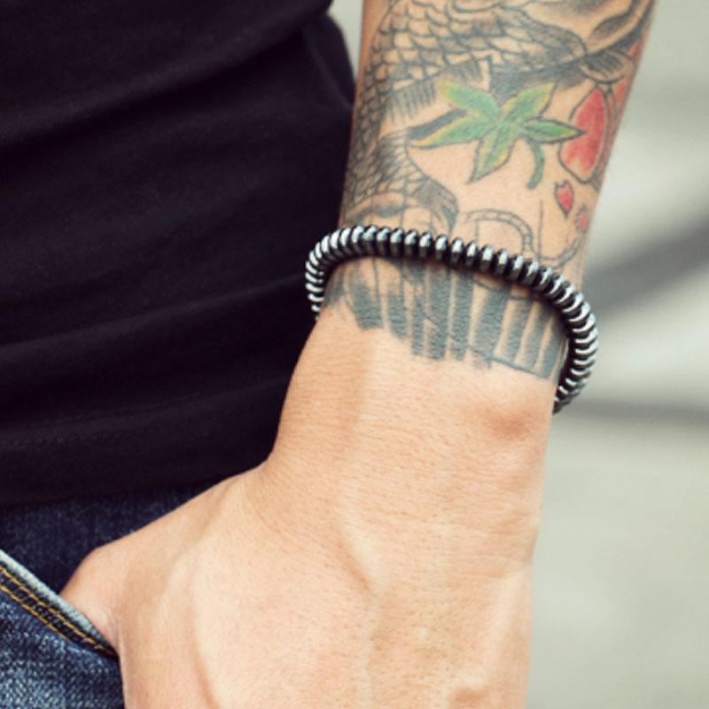 Men's 6mm hematite bracelet woven with nylon rope and red agate stones, showcasing a stylish and modern design.