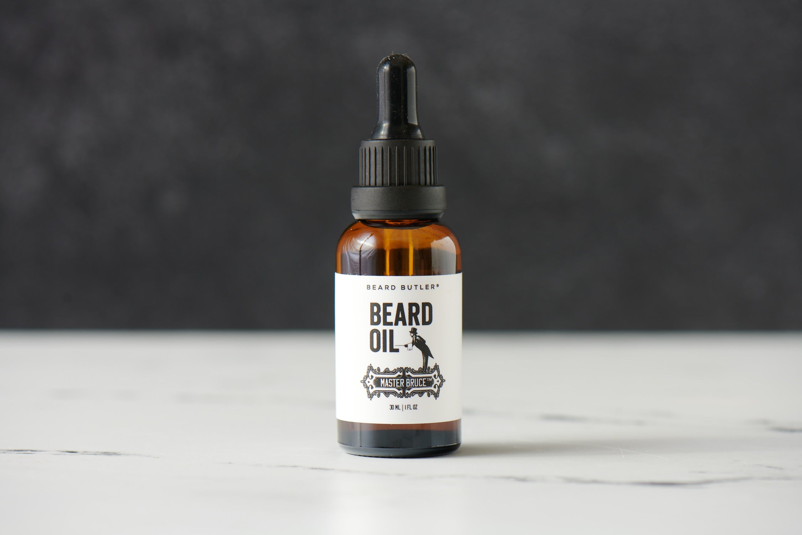 Beard Butler® Master Bruce™ Beard Oil in a dark amber glass bottle, showcasing its natural ingredients and luxurious appeal.