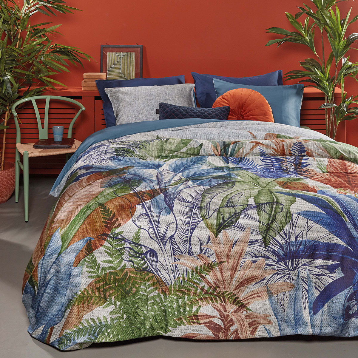 Isla Blue Cotton Sateen Quilt Cover Set featuring tropical foliage print in vibrant colors, with a soft blue backing.