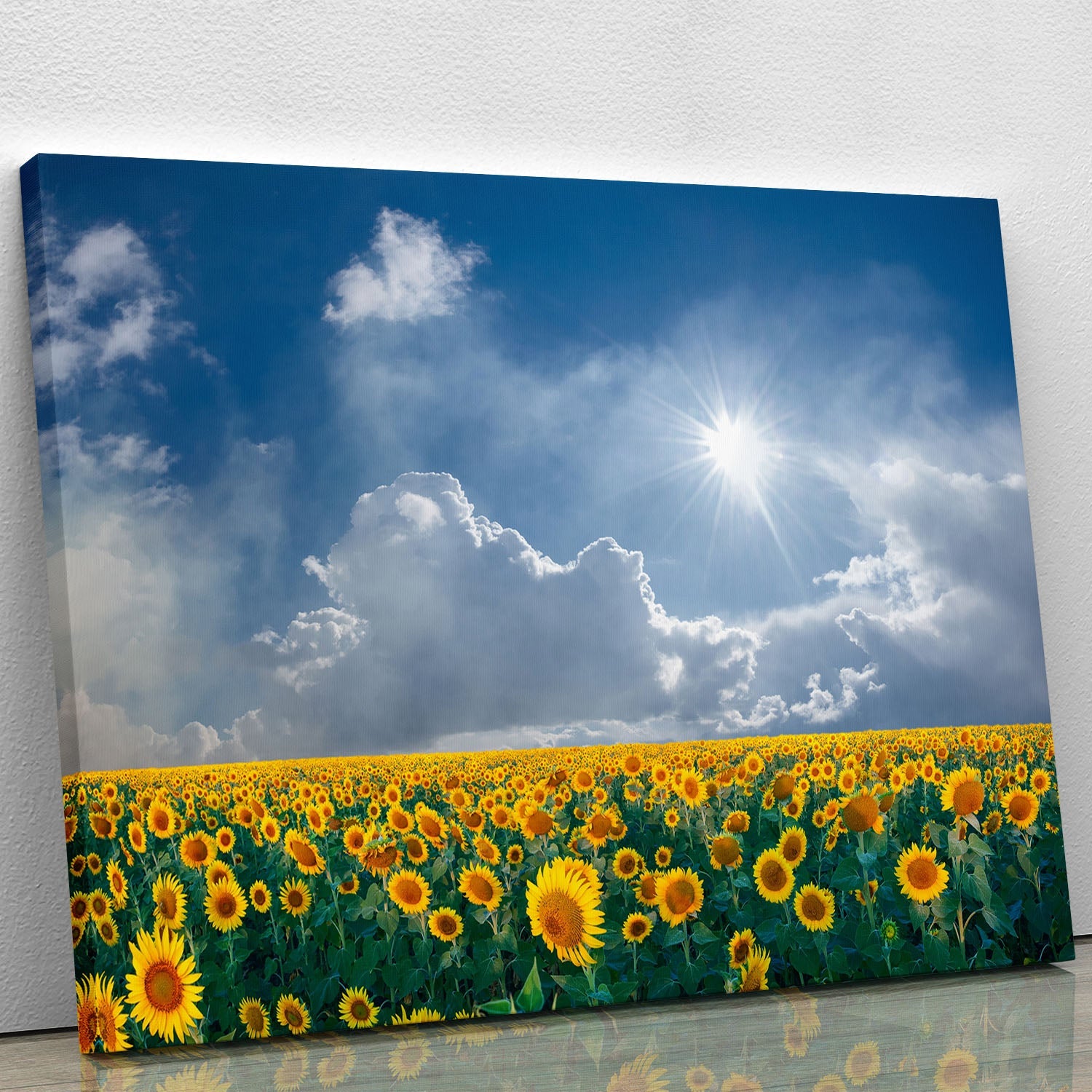 A vibrant canvas print featuring a field of big sunflowers under a clear blue sky, showcasing bright yellow flowers and a serene landscape.