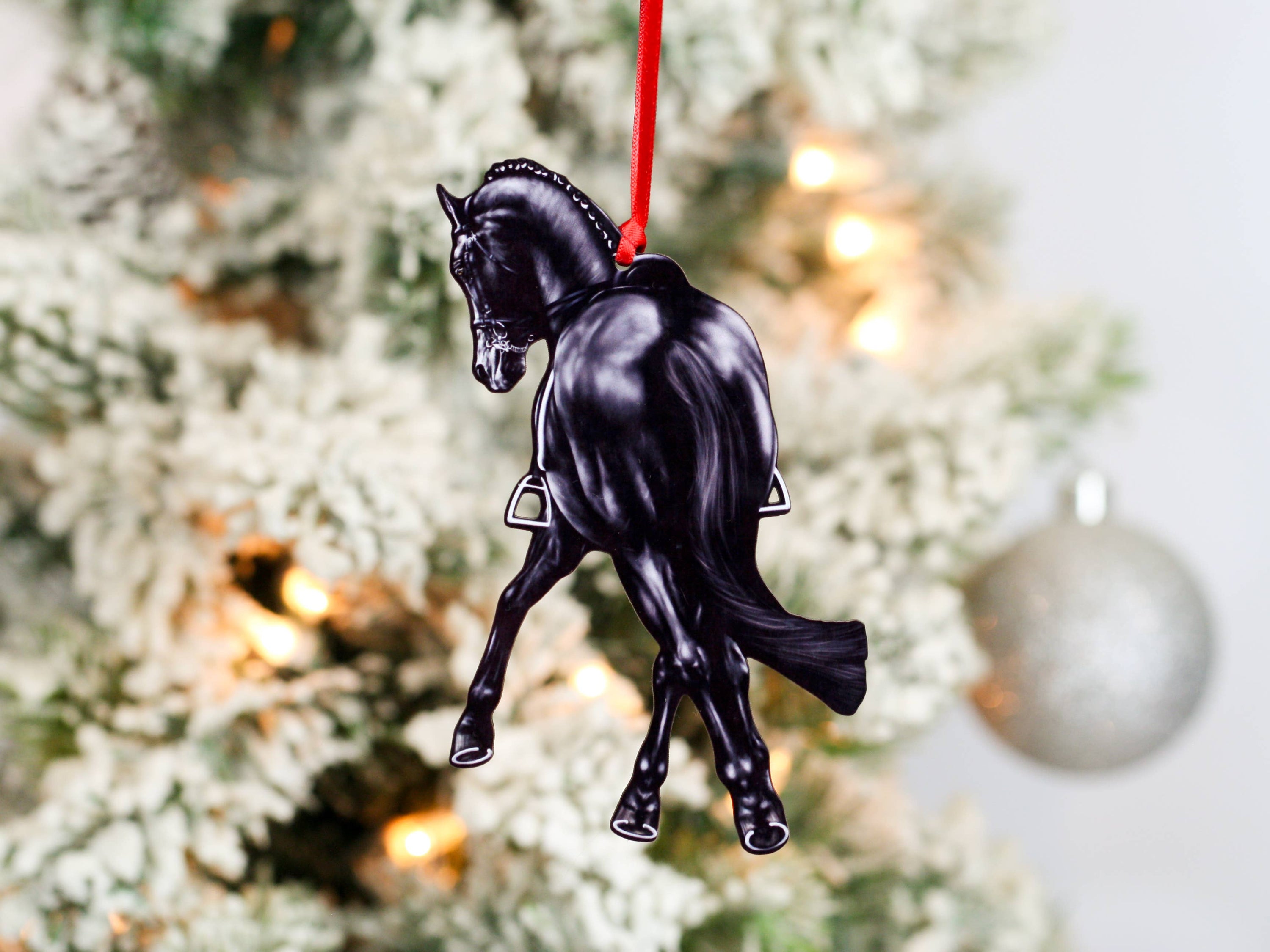 Black Half Pass Dressage Horse Ornament showcasing a horse in motion, made from composite wood with glossy finish and red and black ribbons.