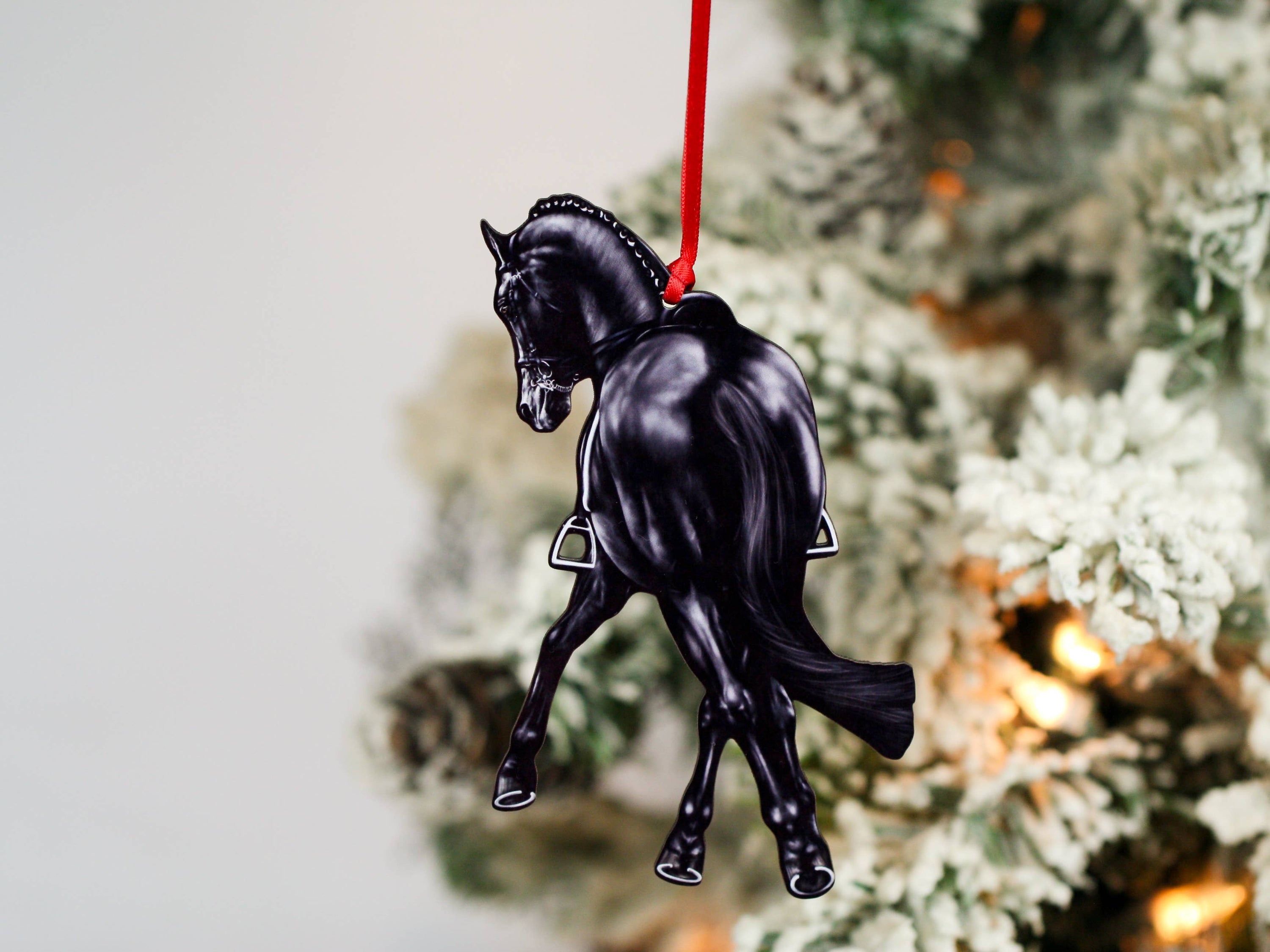 Black Half Pass Dressage Horse Ornament showcasing a horse in motion, made from composite wood with glossy finish and red and black ribbons.