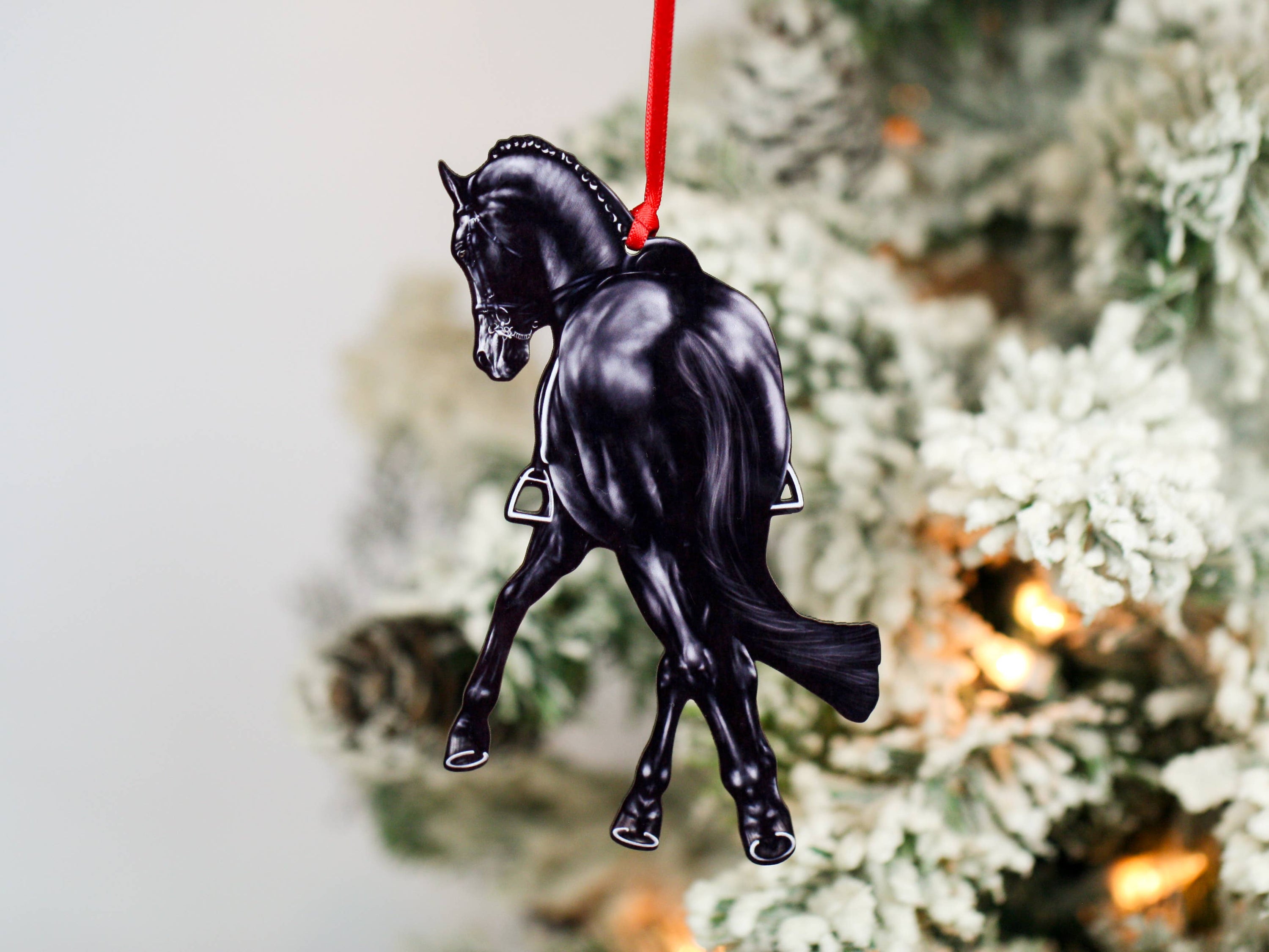 Black Half Pass Dressage Horse Ornament showcasing a horse in motion, made from composite wood with glossy finish and red and black ribbons.