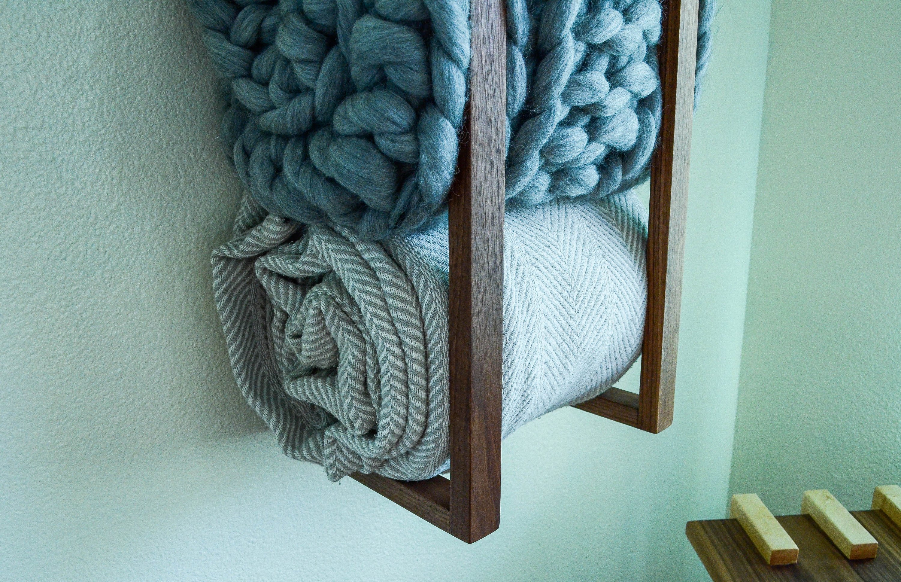 Modern and minimalist blanket wall rack made from American Walnut, showcasing its elegant design and functionality.