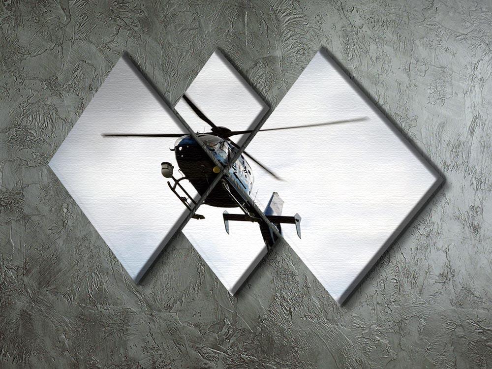 A blue and silver police helicopter flying above a 4-square canvas artwork, showcasing vibrant colors and modern design.