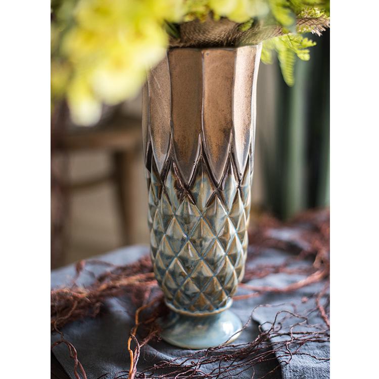 A collection of four blue and gold glazed ceramic vases with a grid pattern, showcasing their unique shapes and textures.