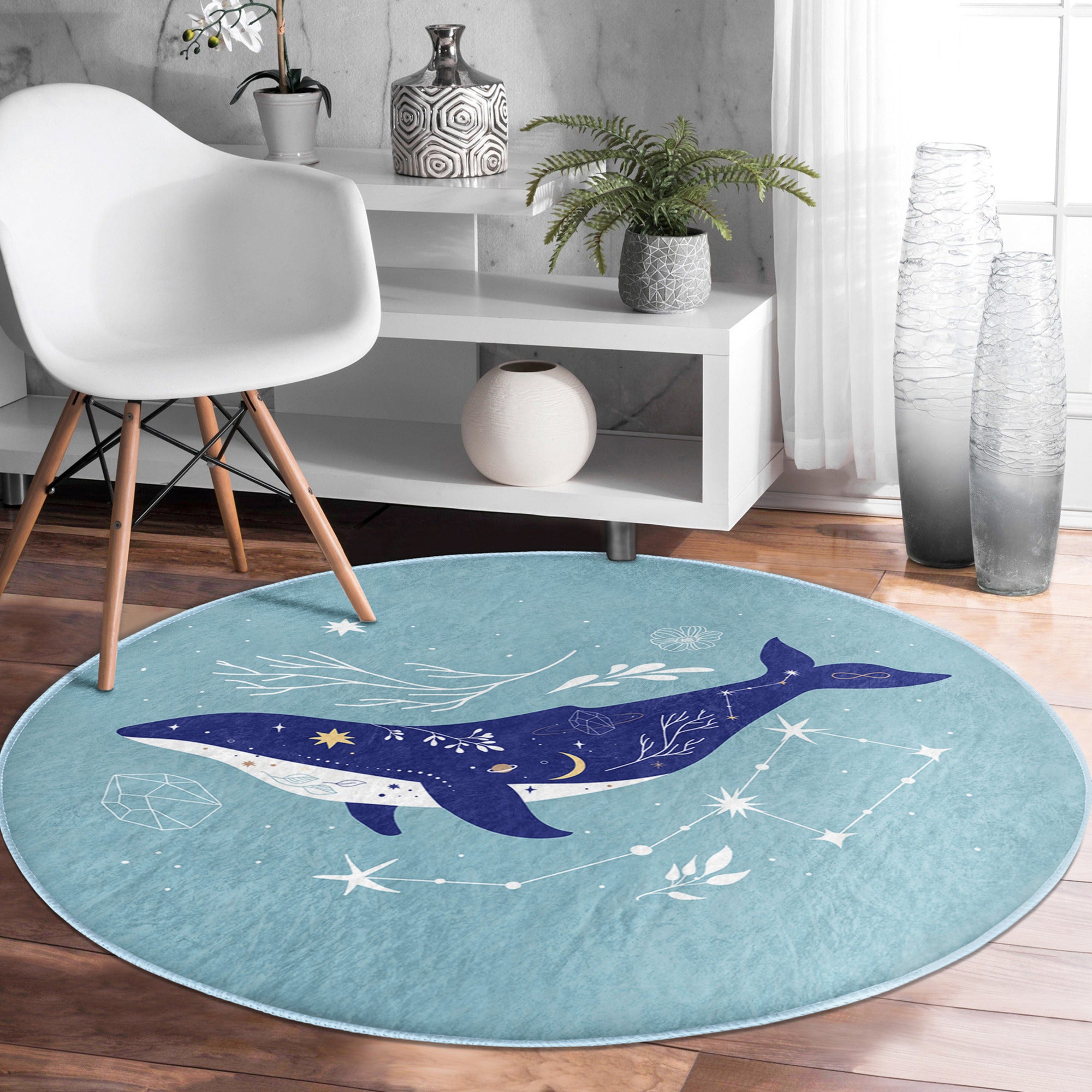 A soft, round rug featuring a vibrant blue whale pattern, perfect for kids' rooms and nurseries, showcasing its plush texture and colorful design.