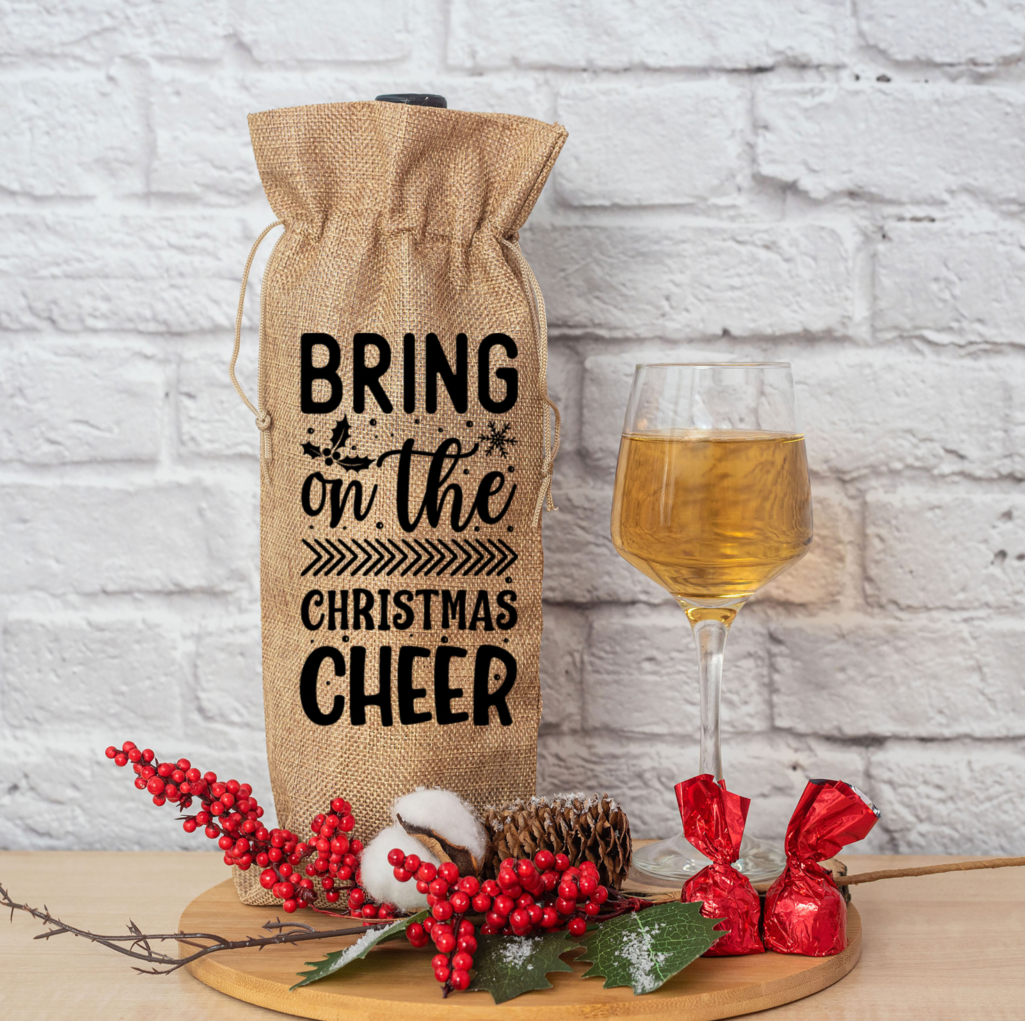 A festive burlap wine bag with a drawstring closure, designed for gifting wine or liquor bottles during the holiday season.