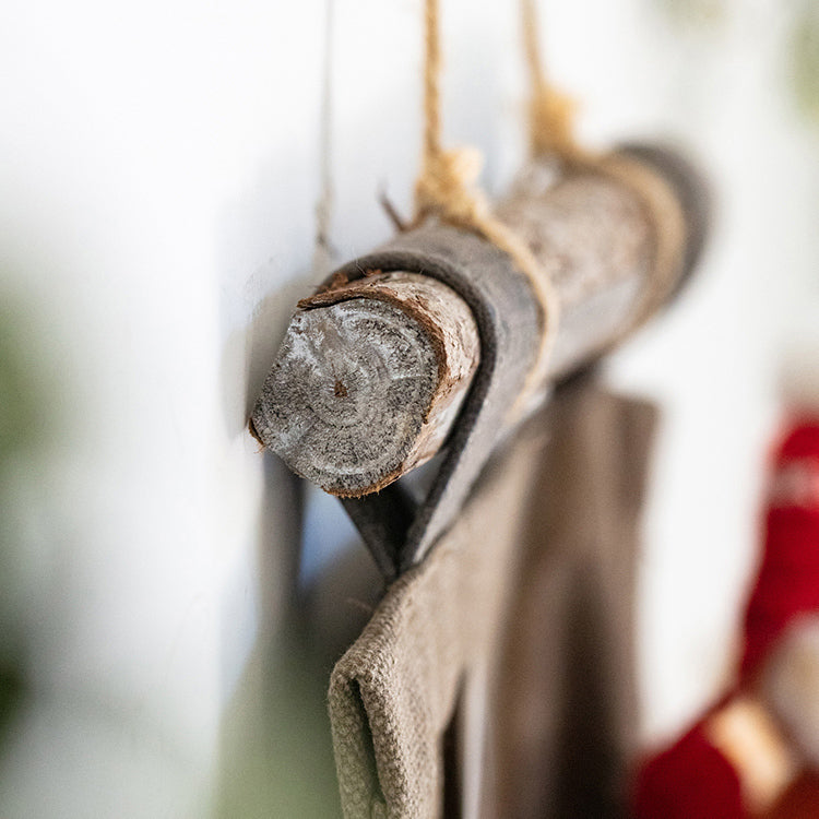 Brown canvas hanging wall storage organizer for garden tools, featuring multiple pockets and a rustic design.