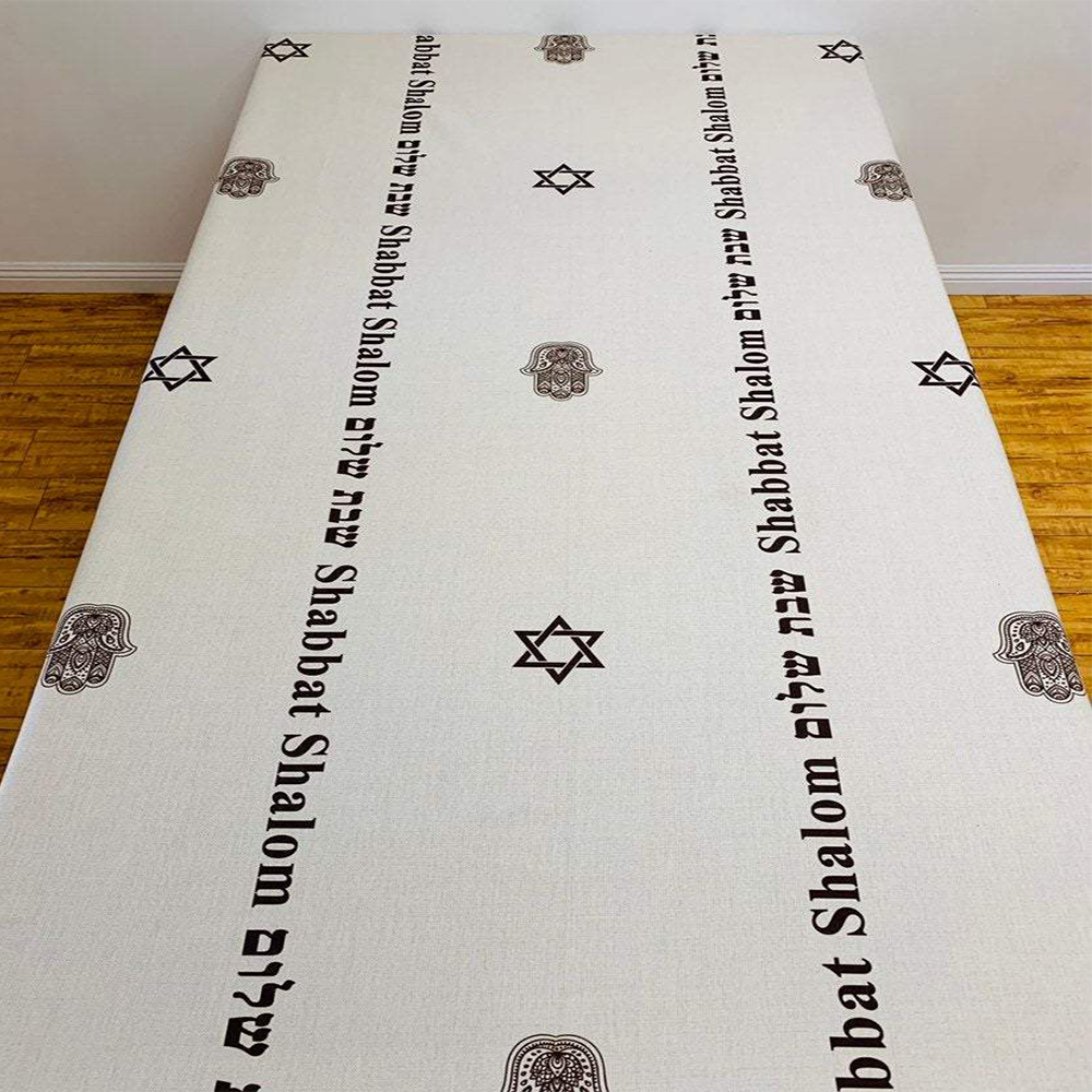 Brown Shabbat Shalom tablecloth featuring Shabbat Shalom stripes in English and Hebrew, adorned with Magen David and Hamsa details.