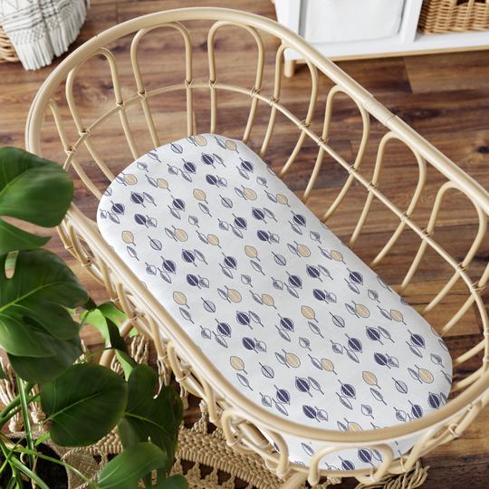 Bubba Blue Night Sky Bamboo Jersey Bassinet Fitted Sheet featuring a navy blue background with white and amber yellow leaf prints.