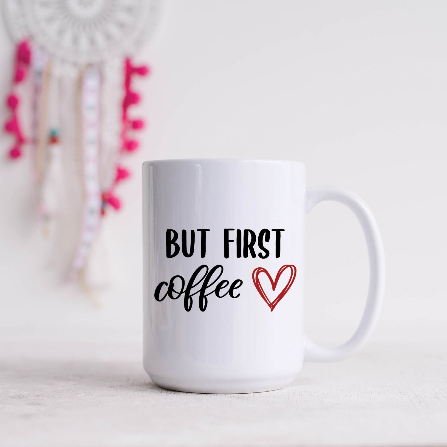A glossy white 15oz ceramic mug with the phrase 'But First Coffee' printed in bold typography.