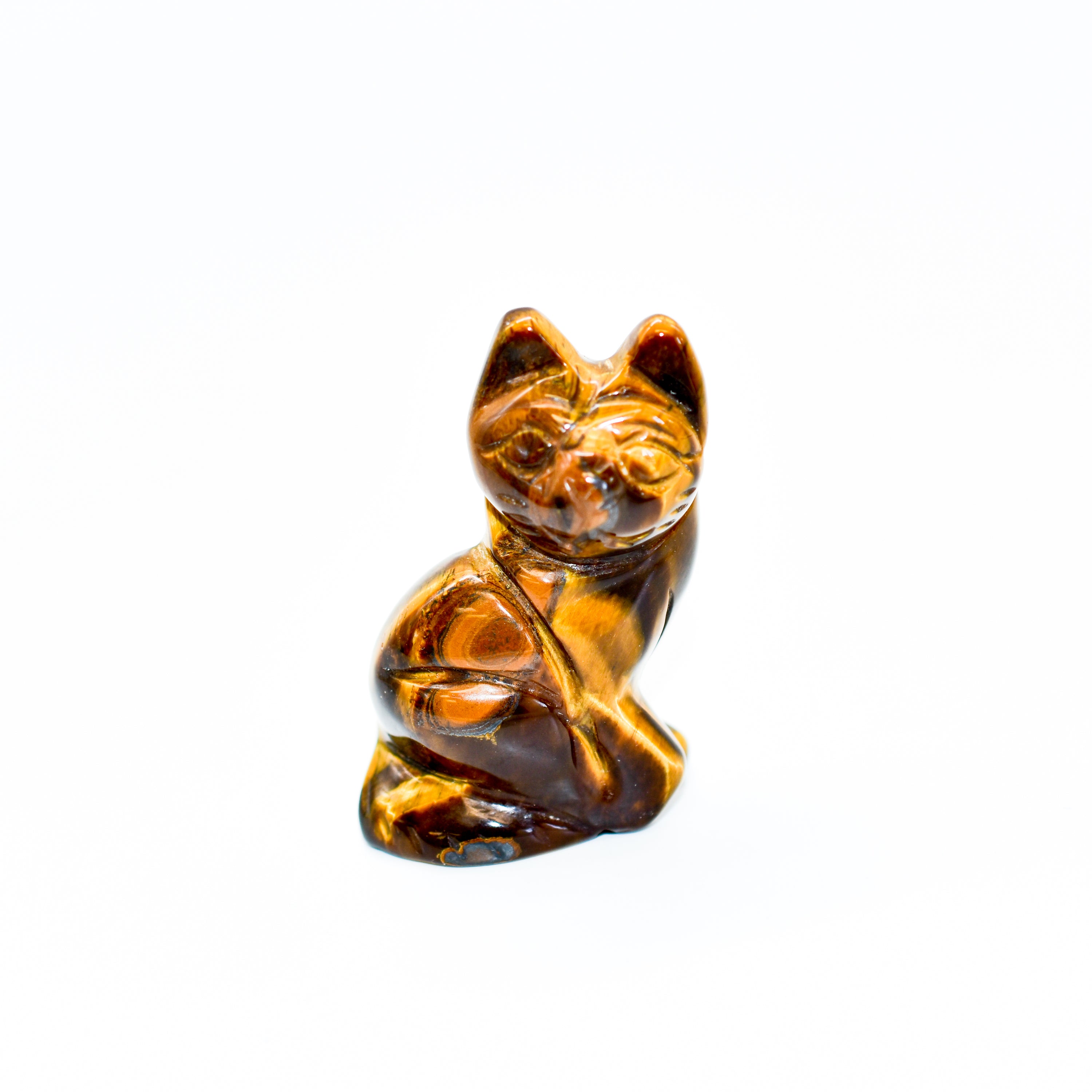 A collection of beautifully crafted cat crystal carvings in various poses, made from natural stones like Rose Quartz and Tiger's Eye.