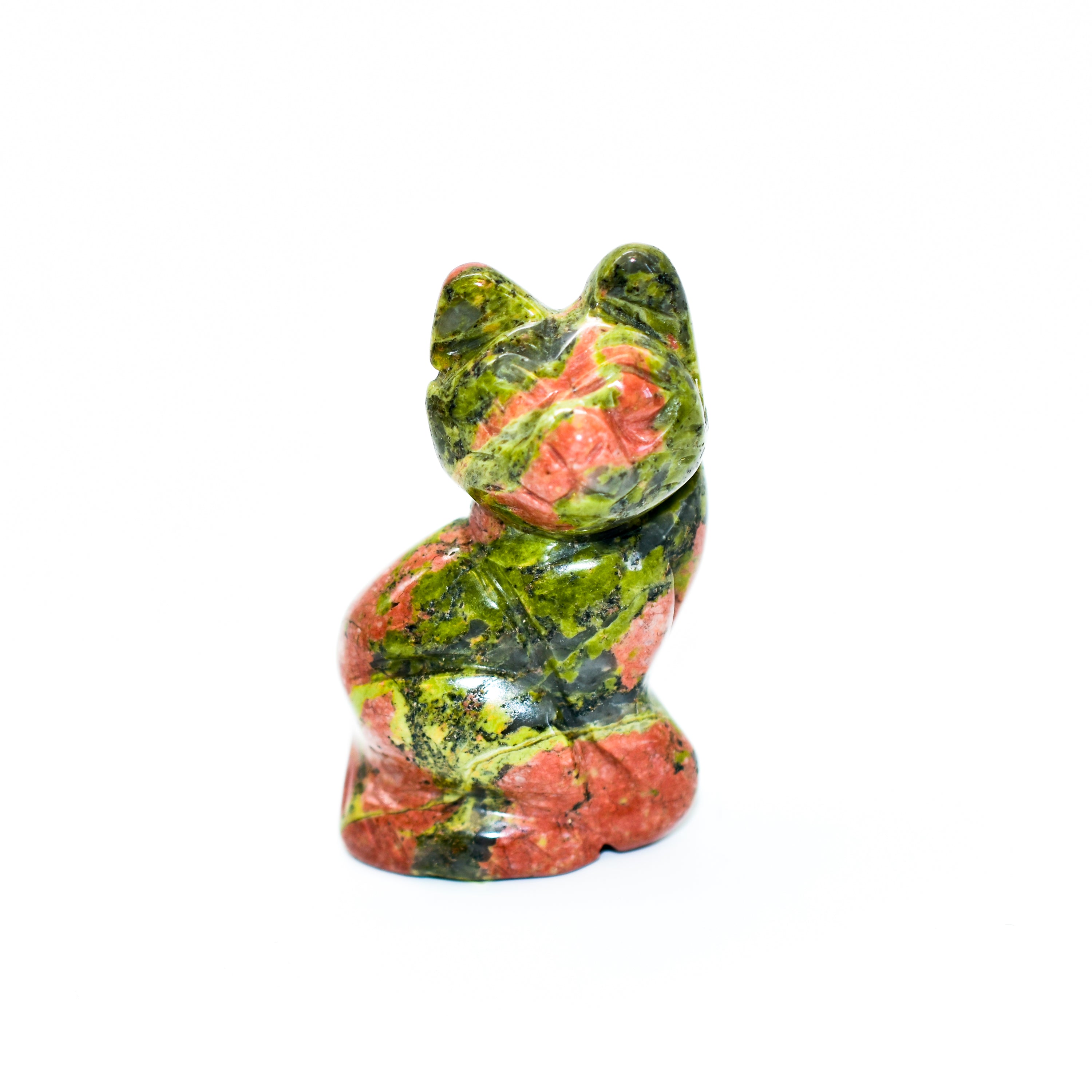 A collection of beautifully crafted cat crystal carvings in various poses, made from natural stones like Rose Quartz and Tiger's Eye.