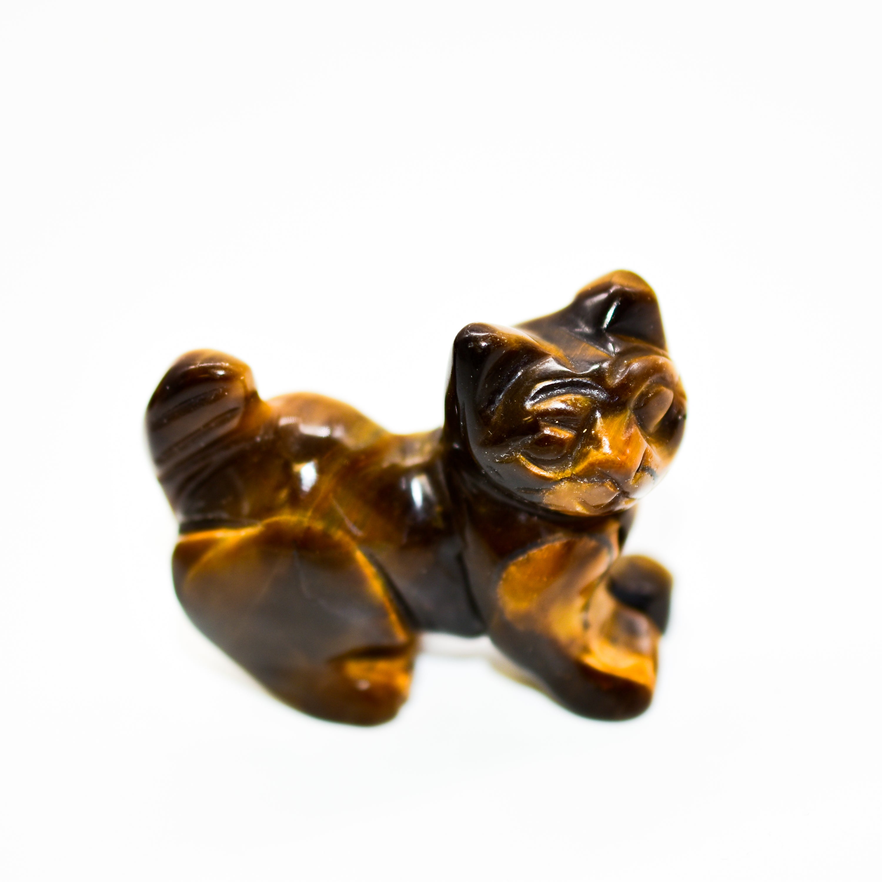 A collection of beautifully crafted cat crystal carvings in various poses, made from natural stones like Rose Quartz and Tiger's Eye.