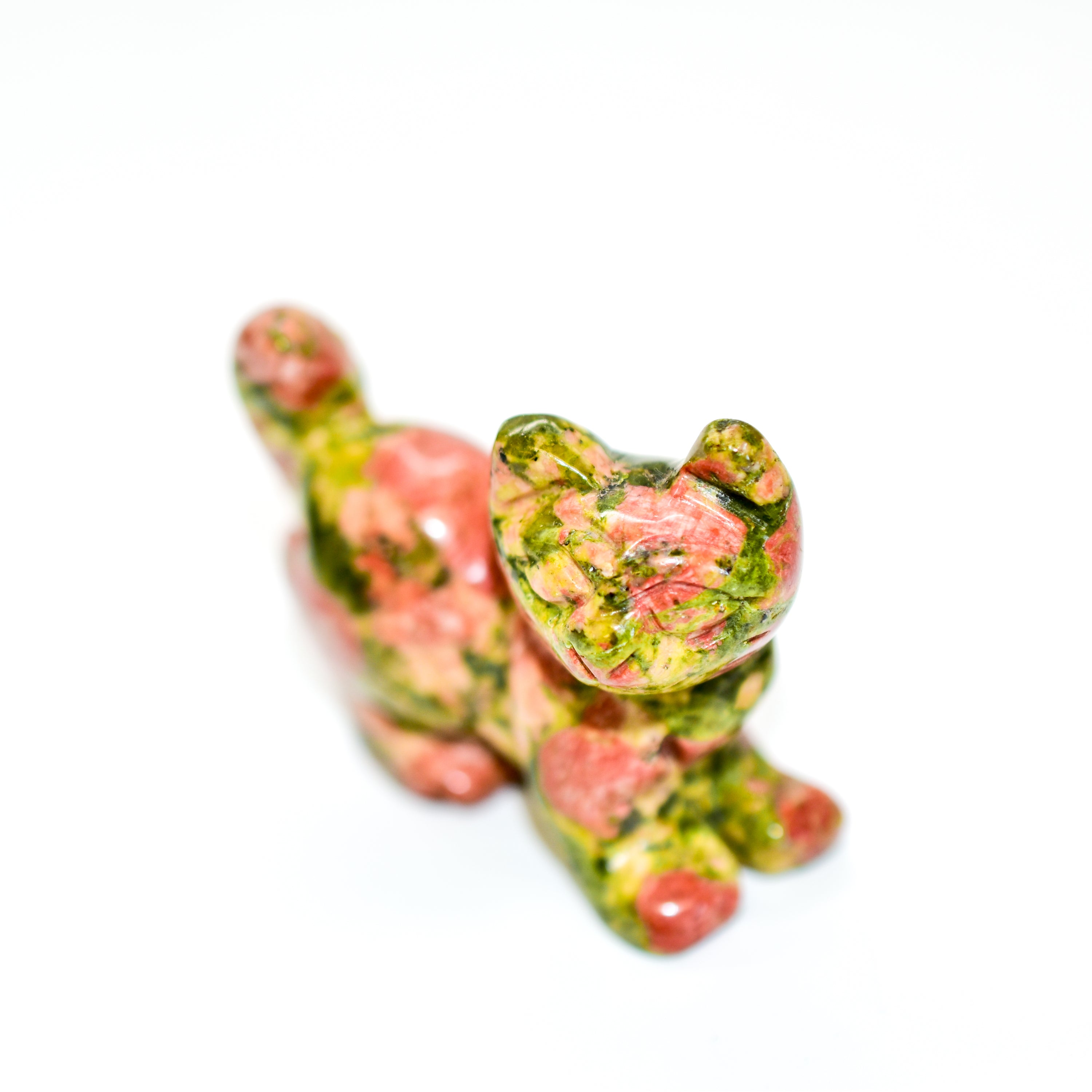 A collection of beautifully crafted cat crystal carvings in various poses, made from natural stones like Rose Quartz and Tiger's Eye.