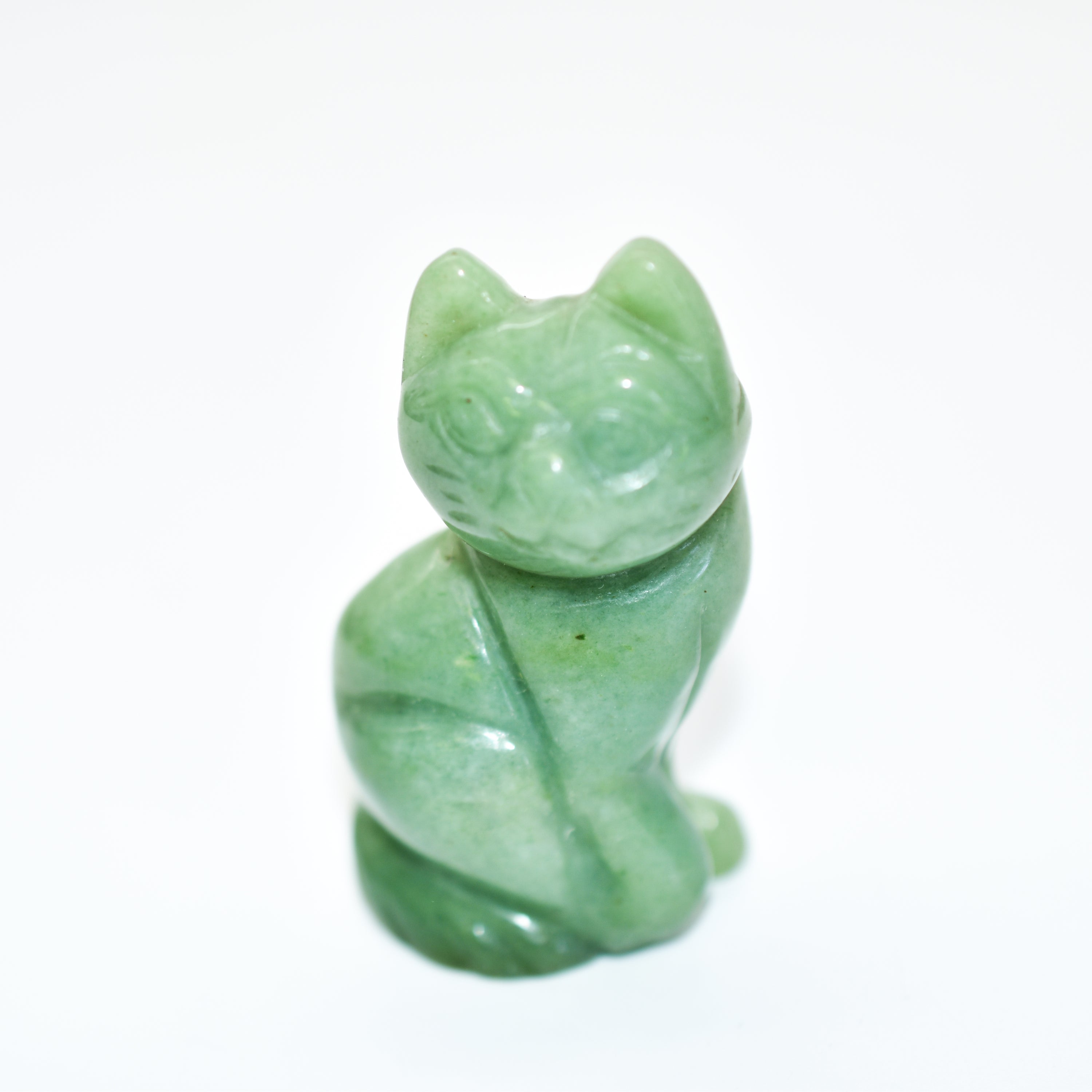 A collection of beautifully crafted cat crystal carvings in various poses, made from natural stones like Rose Quartz and Tiger's Eye.