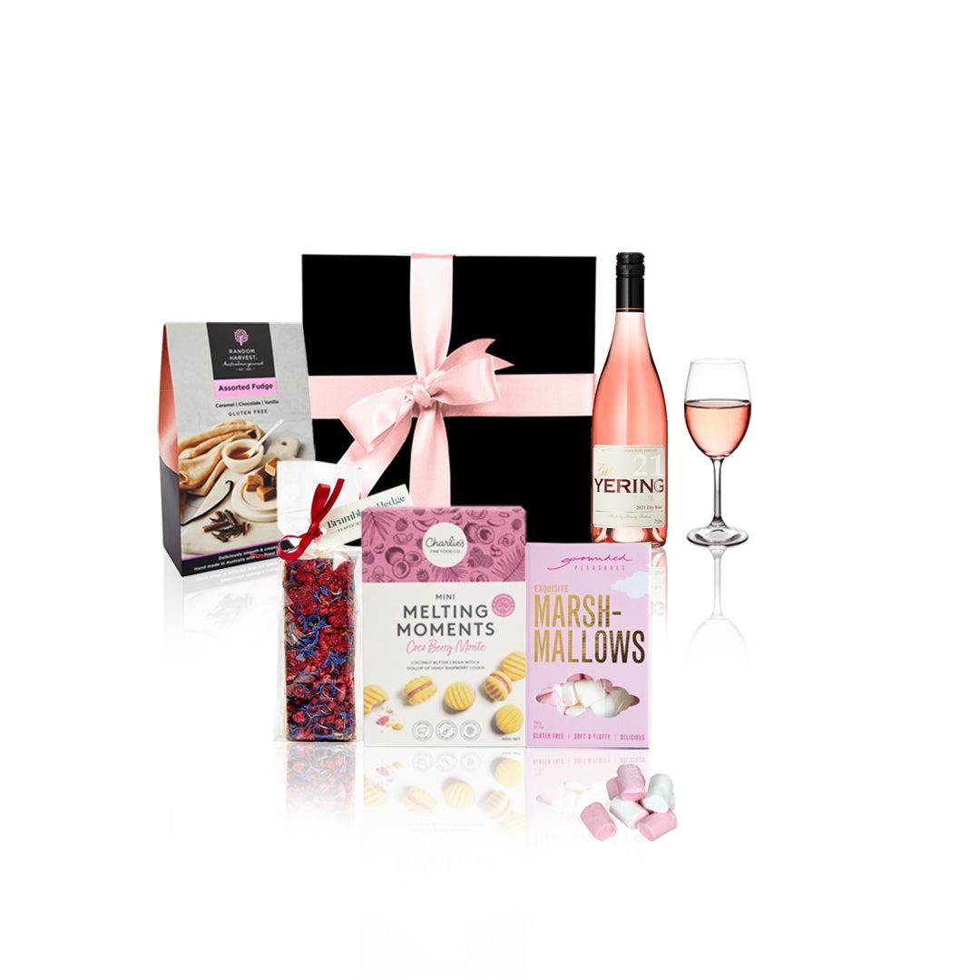 Celebrate with Rose Hamper featuring gourmet treats and a bottle of Yering Station Rose wine in an elegant black box with a pink satin bow.