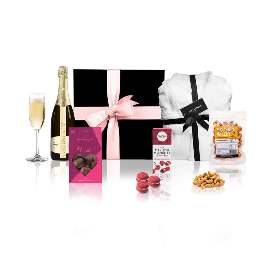 Chandon & Linenhouse Gift Hamper featuring a bottle of Chandon Brut, a white bathrobe, chocolates, and nuts in an elegant black box with a pink bow.