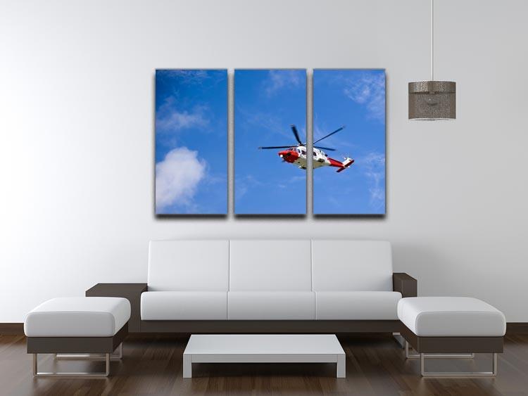 A stunning 3-panel canvas print featuring a Coastguard helicopter soaring in a clear blue sky, perfect for home or office decor.