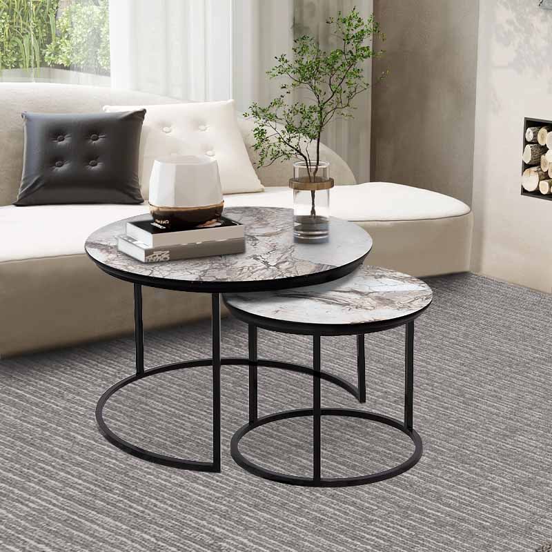 JULIUS Coffee Table Set featuring beige marble effect and black metal base, showcasing two round tables in a stylish living room setting.