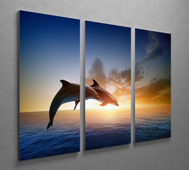 A beautiful 3-panel canvas print featuring two dolphins jumping in the ocean, showcasing vibrant colors and dynamic movement.