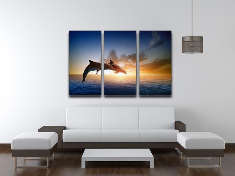 A beautiful 3-panel canvas print featuring two dolphins jumping in the ocean, showcasing vibrant colors and dynamic movement.