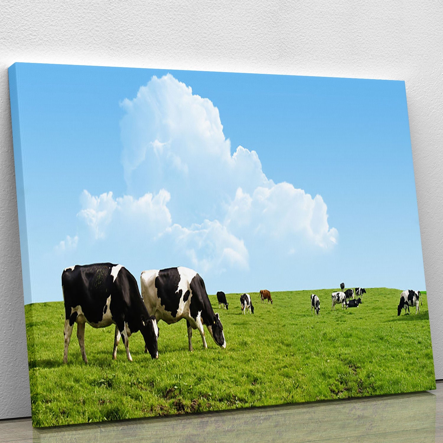 A beautiful canvas print of cows grazing in a lush green field, showcasing serene rural life.