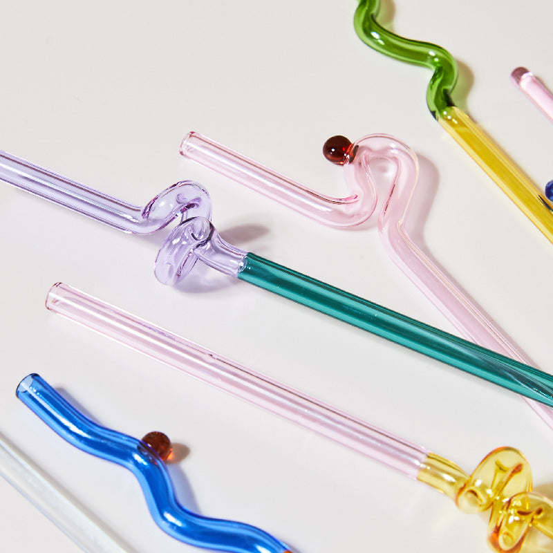 Curvy Glass Straw Set featuring colorful, elegant straws made from durable borosilicate glass, with a cleaning brush included.