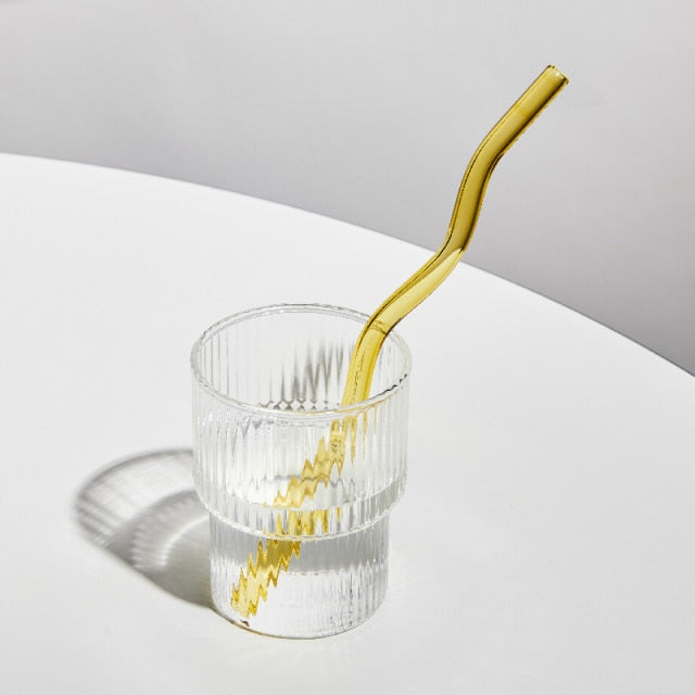 Curvy Glass Straw Set featuring colorful, elegant straws made from durable borosilicate glass, with a cleaning brush included.
