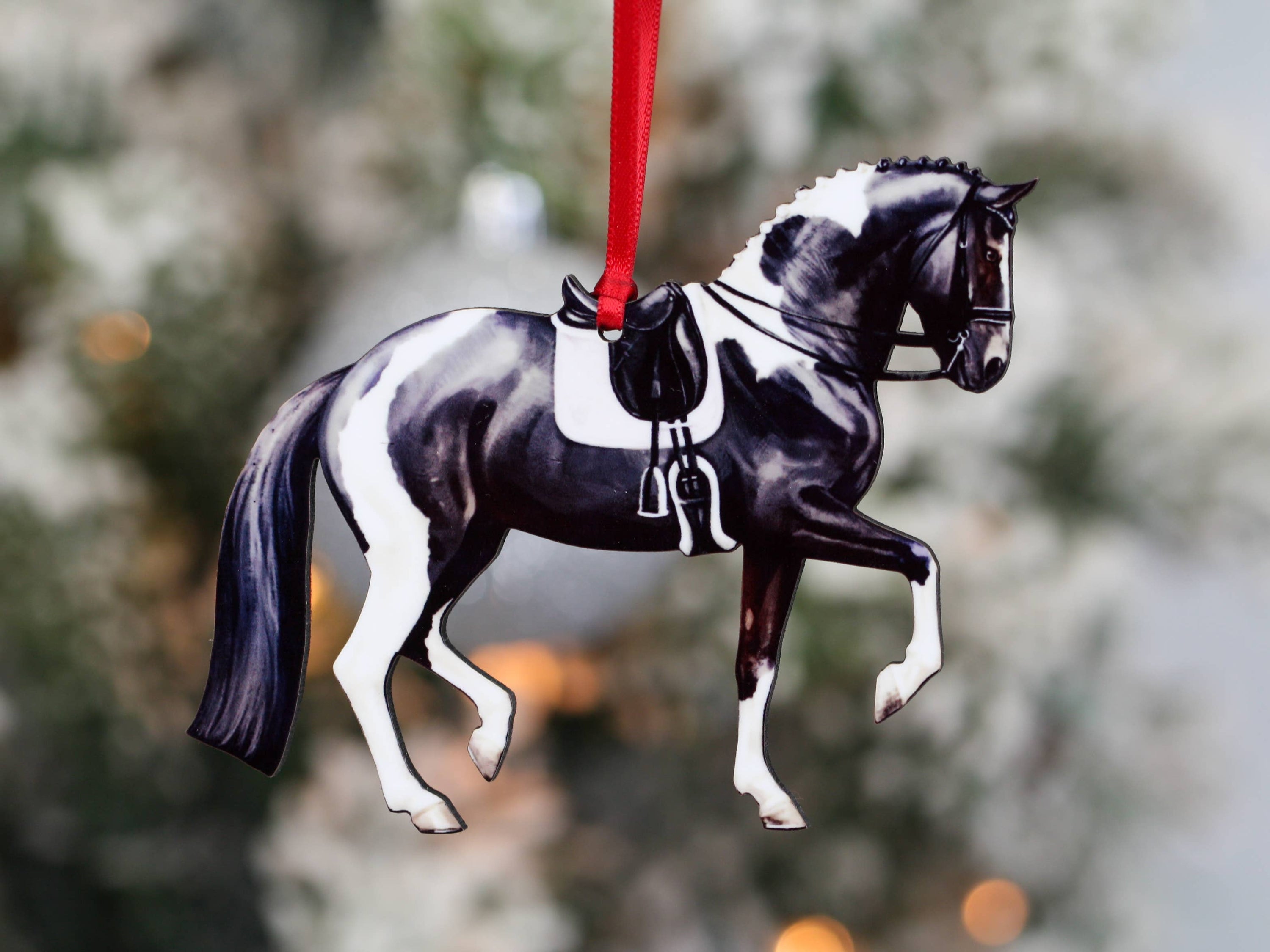 Black and white tobiano sport horse ornament, handmade from composite wood, featuring a glossy front and dark brown back.