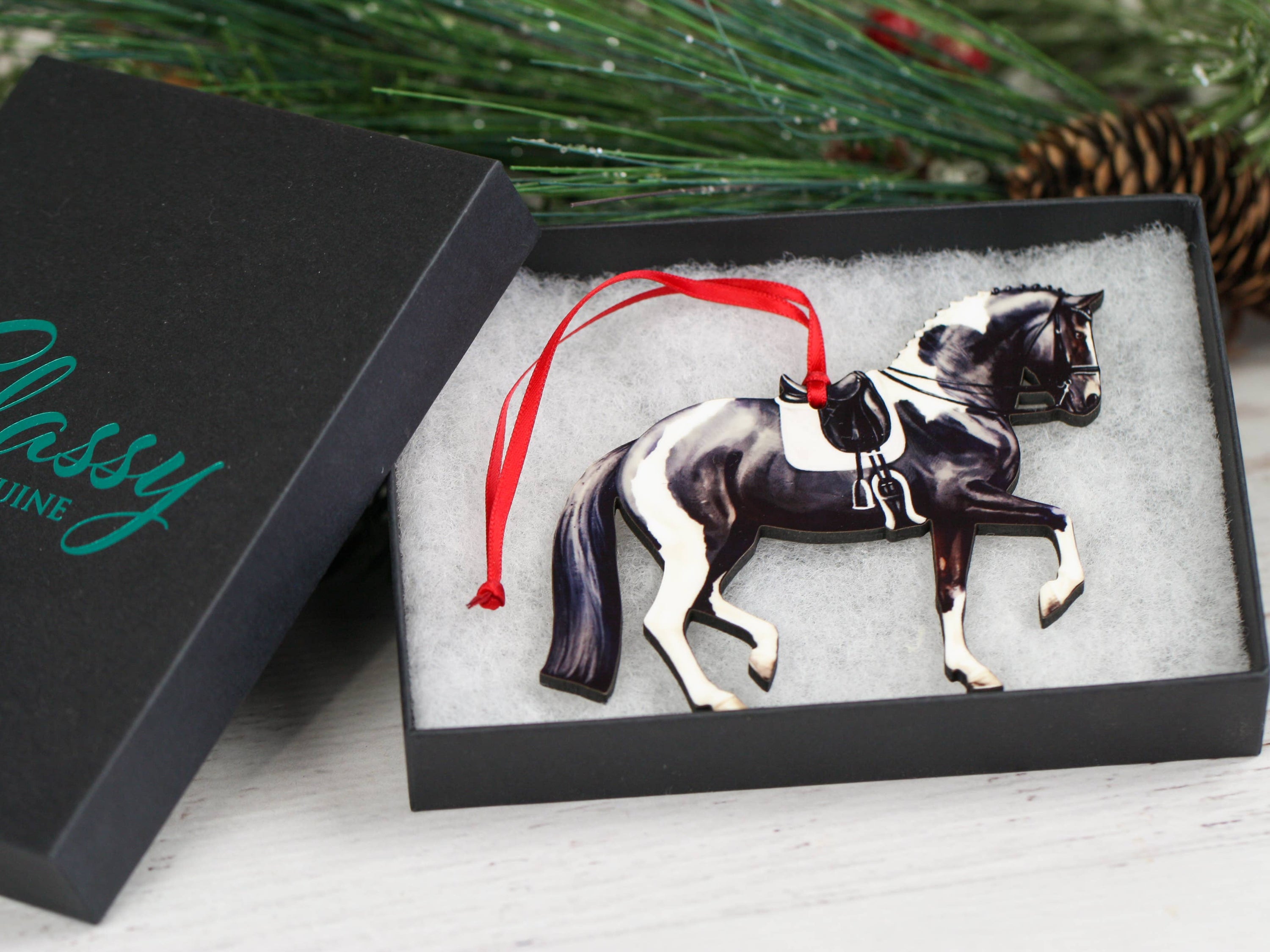 Black and white tobiano sport horse ornament, handmade from composite wood, featuring a glossy front and dark brown back.