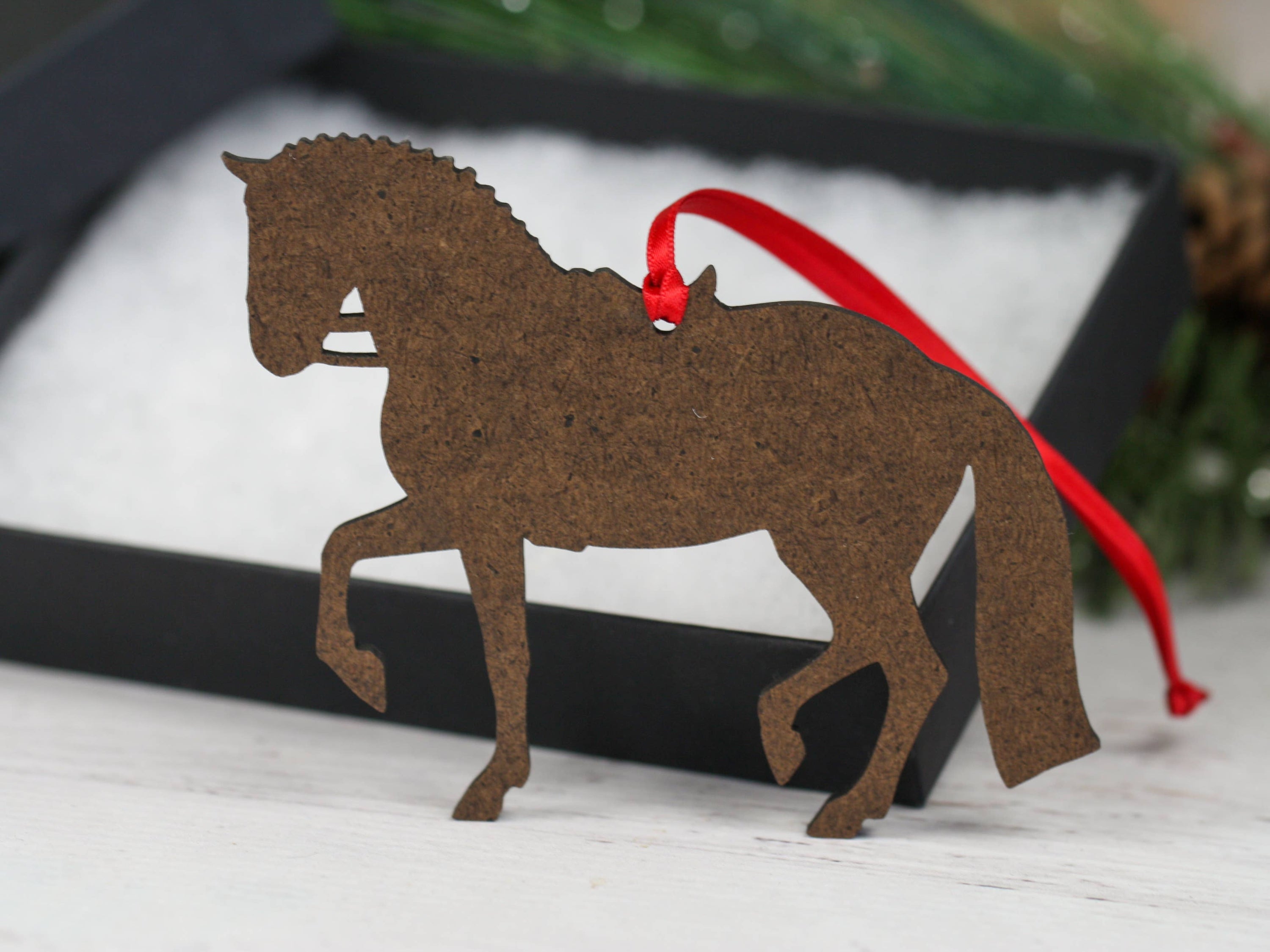 Black and white tobiano sport horse ornament, handmade from composite wood, featuring a glossy front and dark brown back.