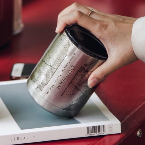 A 10oz insulated stainless steel cup featuring a custom engraved map of Durham, North Carolina, showcasing its coordinates.